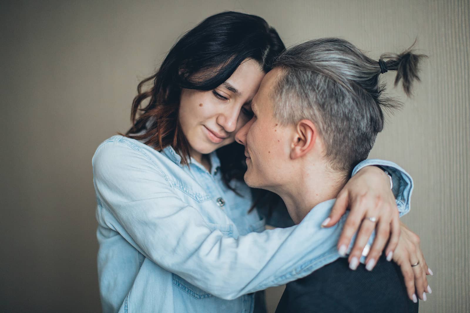 eine Frau umarmt ihren Mann mit geschlossenen Augen