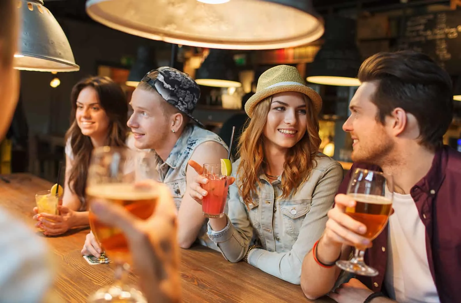 Eine Gruppe von Leuten, die in der Bar rumhängen und Bier trinken