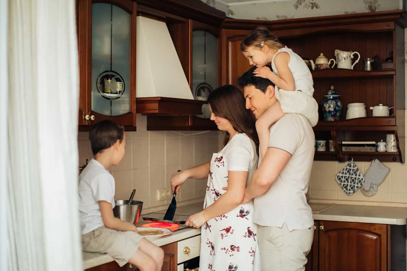 eine glückliche Familie, die Pfannkuchen in der Küche zubereitet
