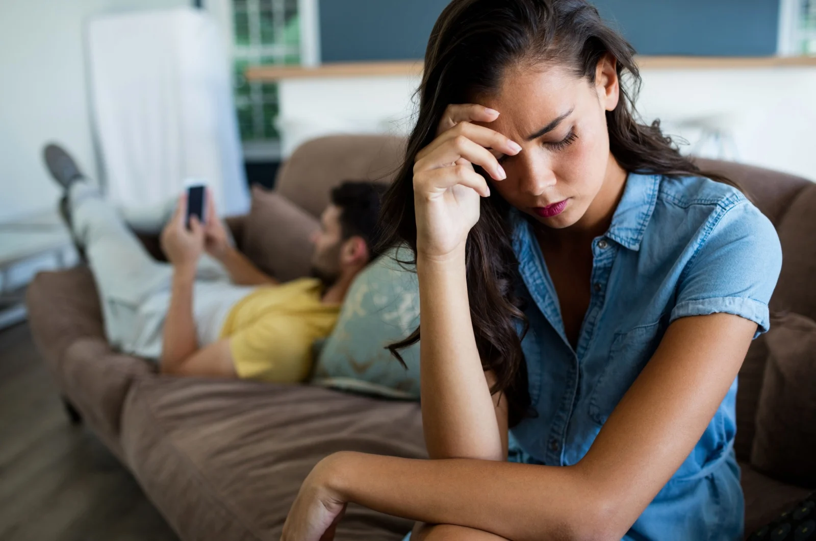traurige Frau sitzt auf der Couch