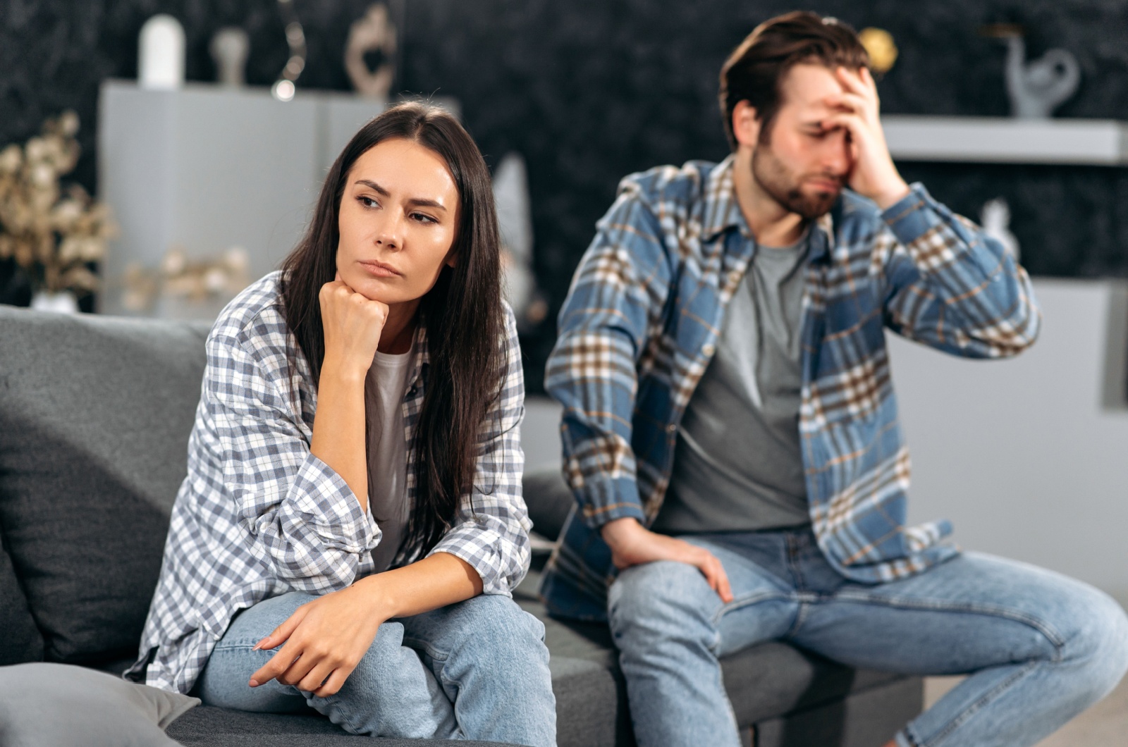 wuetende Frau sitzt auf der Couch
