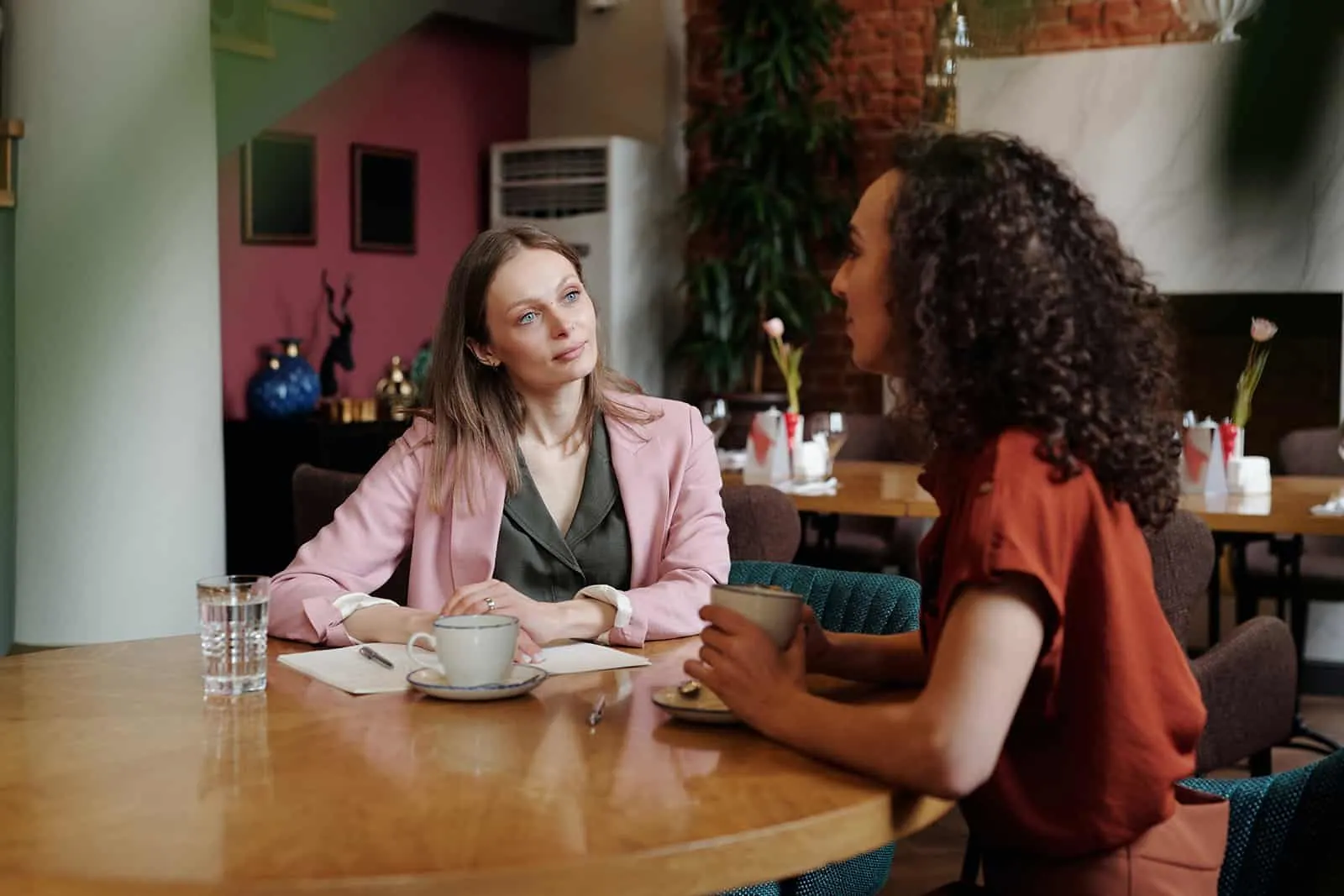 zwei Kolleginnen unterhalten sich während einer Pause beim gemeinsamen Kaffeetrinken
