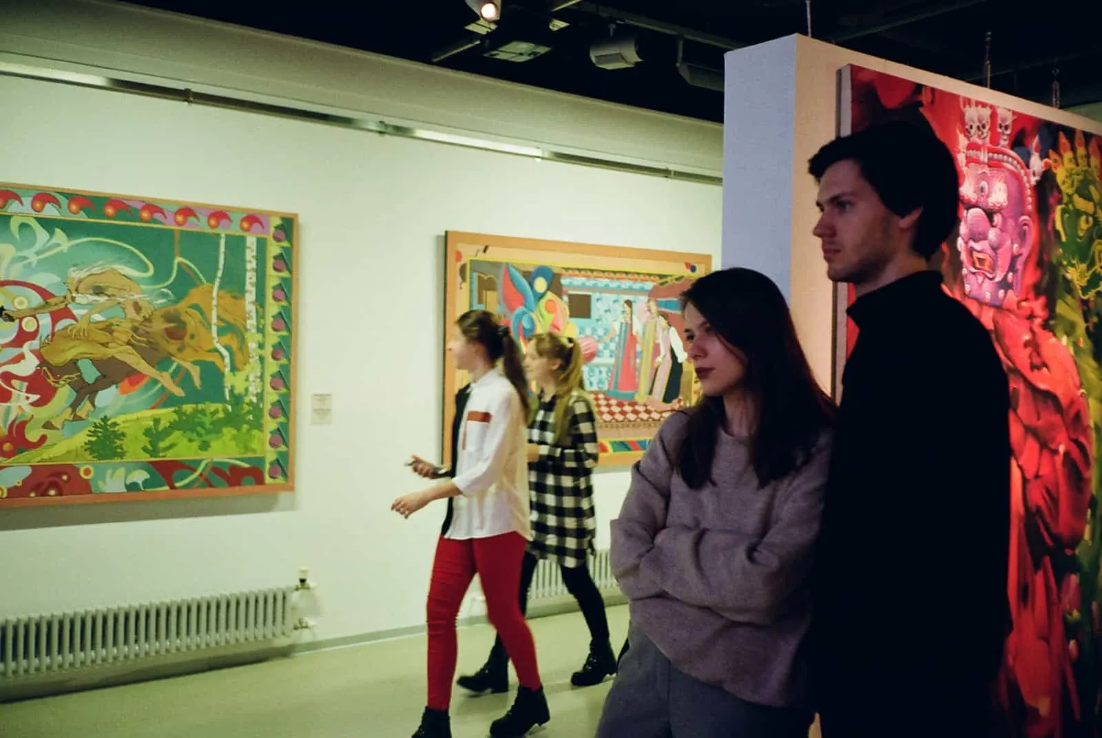 Ein Mann und eine Frau beobachten eine Bilderausstellung in der Kunstgalerie