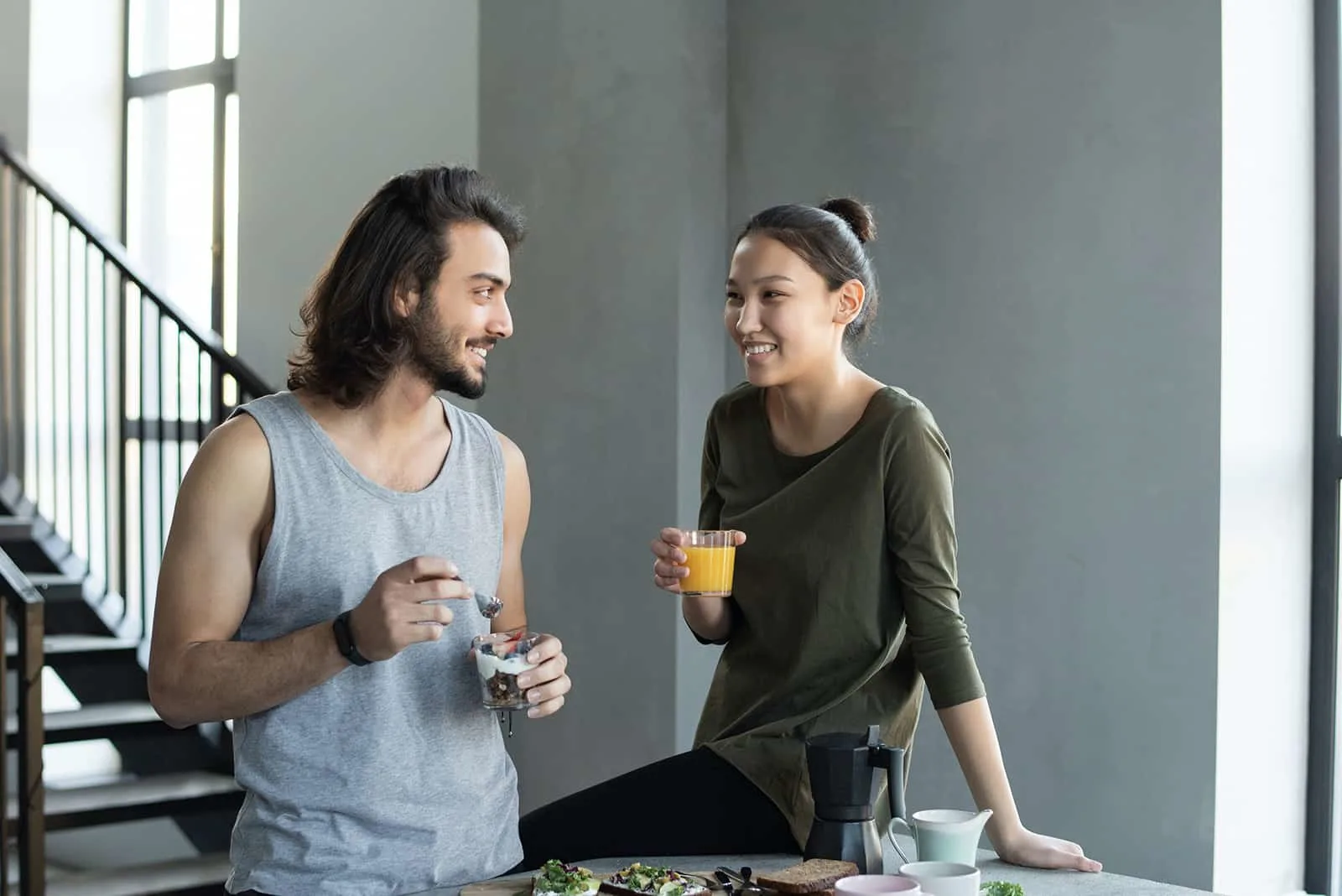 Ein Mann und eine Frau frühstücken zusammen, lächeln und schauen sich an