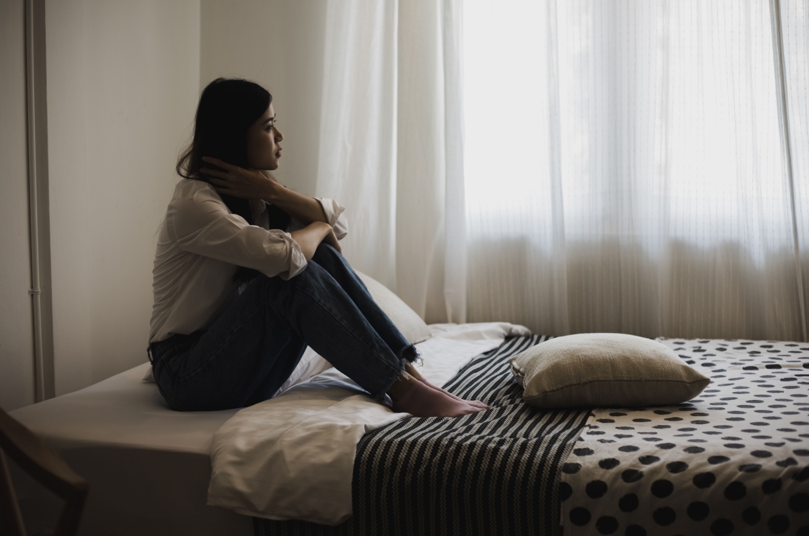 Frau liegt im Bett und denkt nach