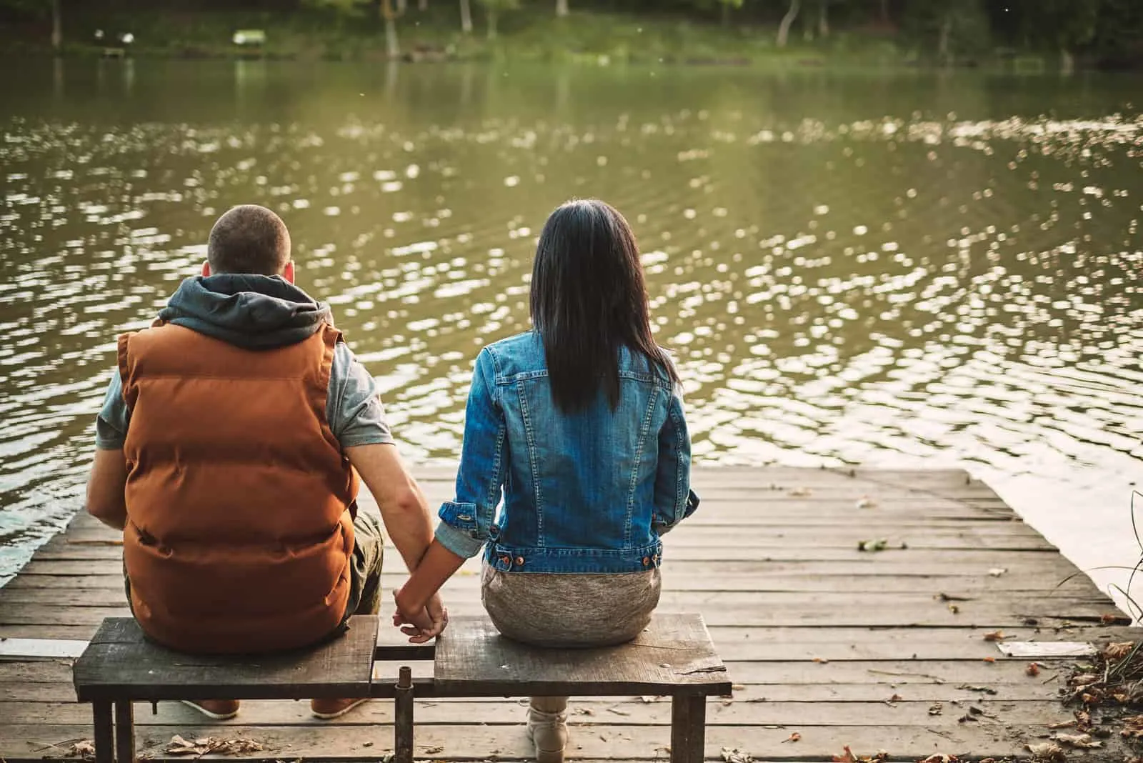 Paar sitzt auf der Bank am See