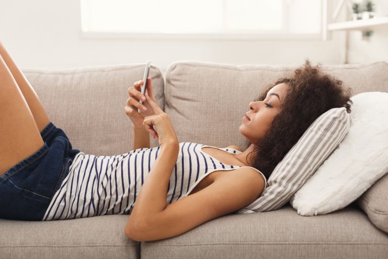 Frau Messaging auf dem Smartphone zu Hause