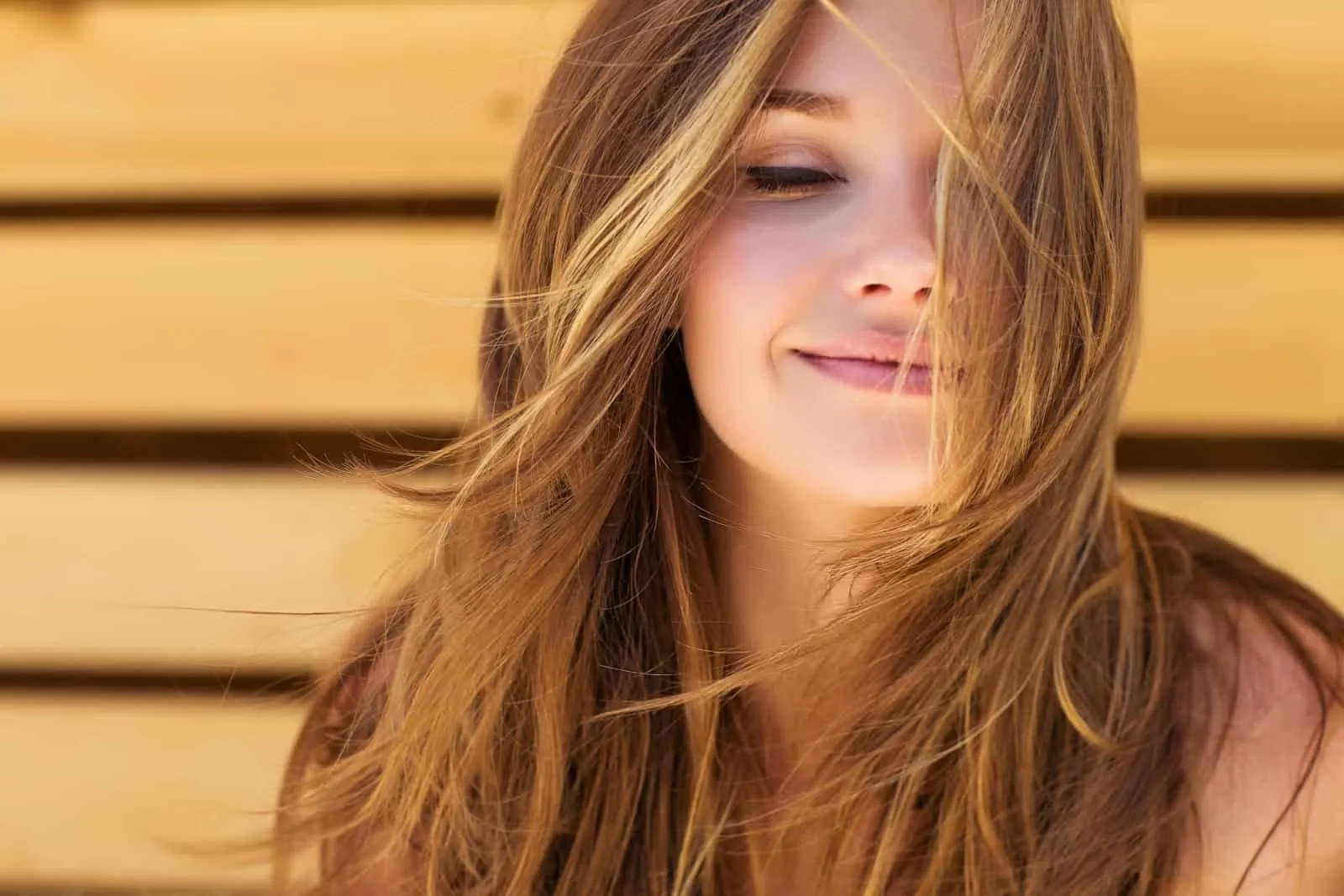 ein lächelndes Mädchen mit dem Wind im Haar
