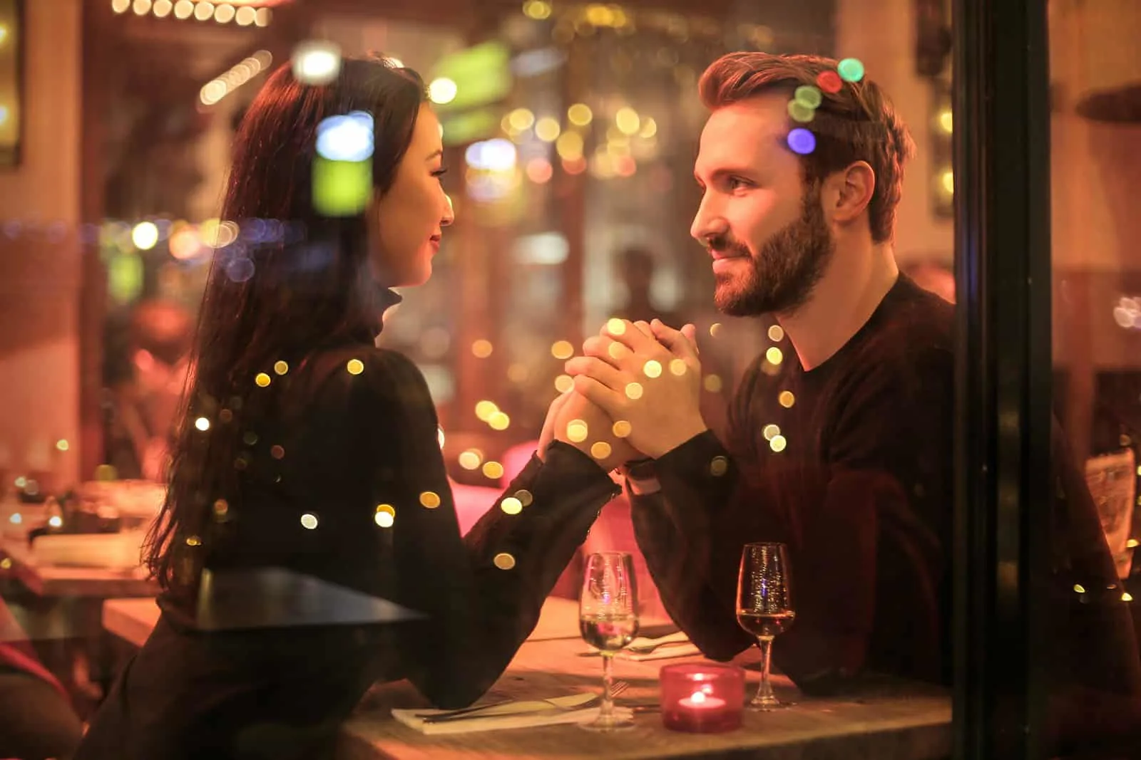 ein Paar Händchen haltend bei einem Date in einem romantischen Restaurant