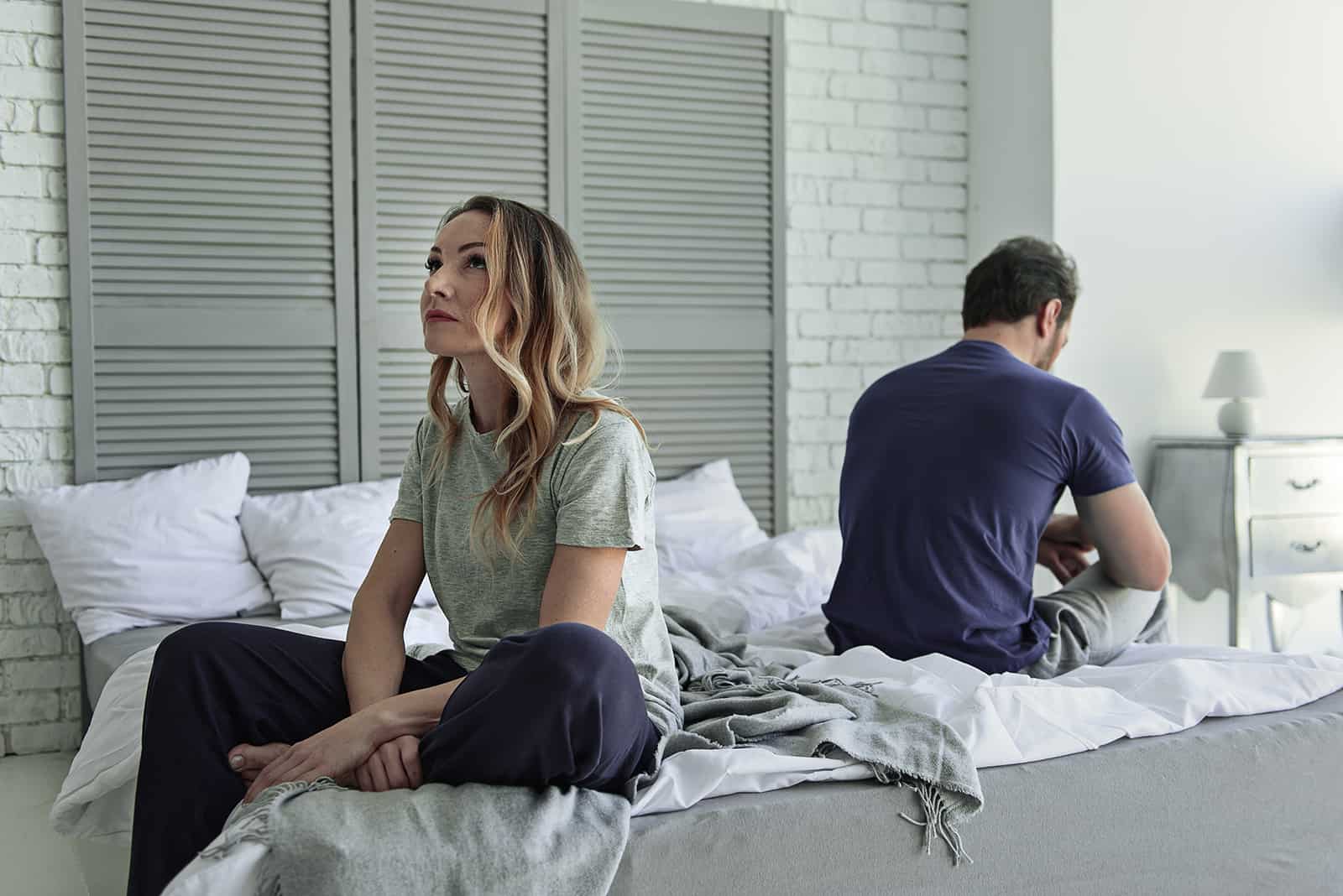 Ein Ehepaar sitzt auf dem Bett und sieht nachdenklich aus