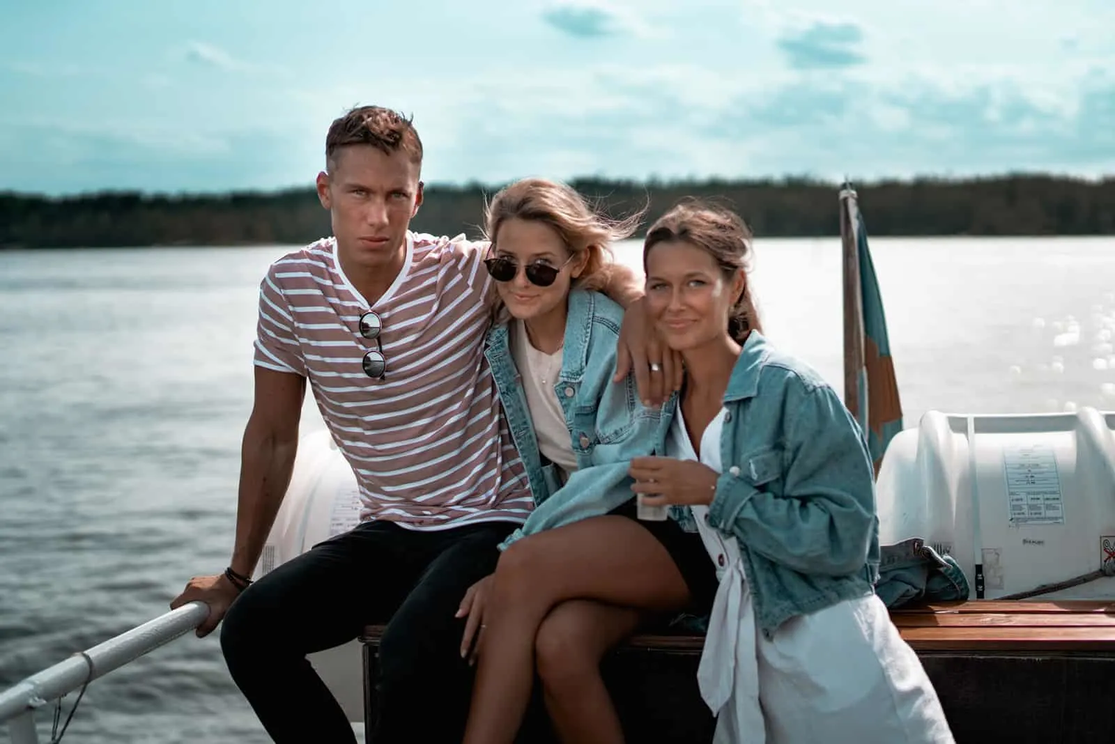 eine Gruppe von Freunden, die auf einem Boot sitzen, während sie für ein Foto posieren