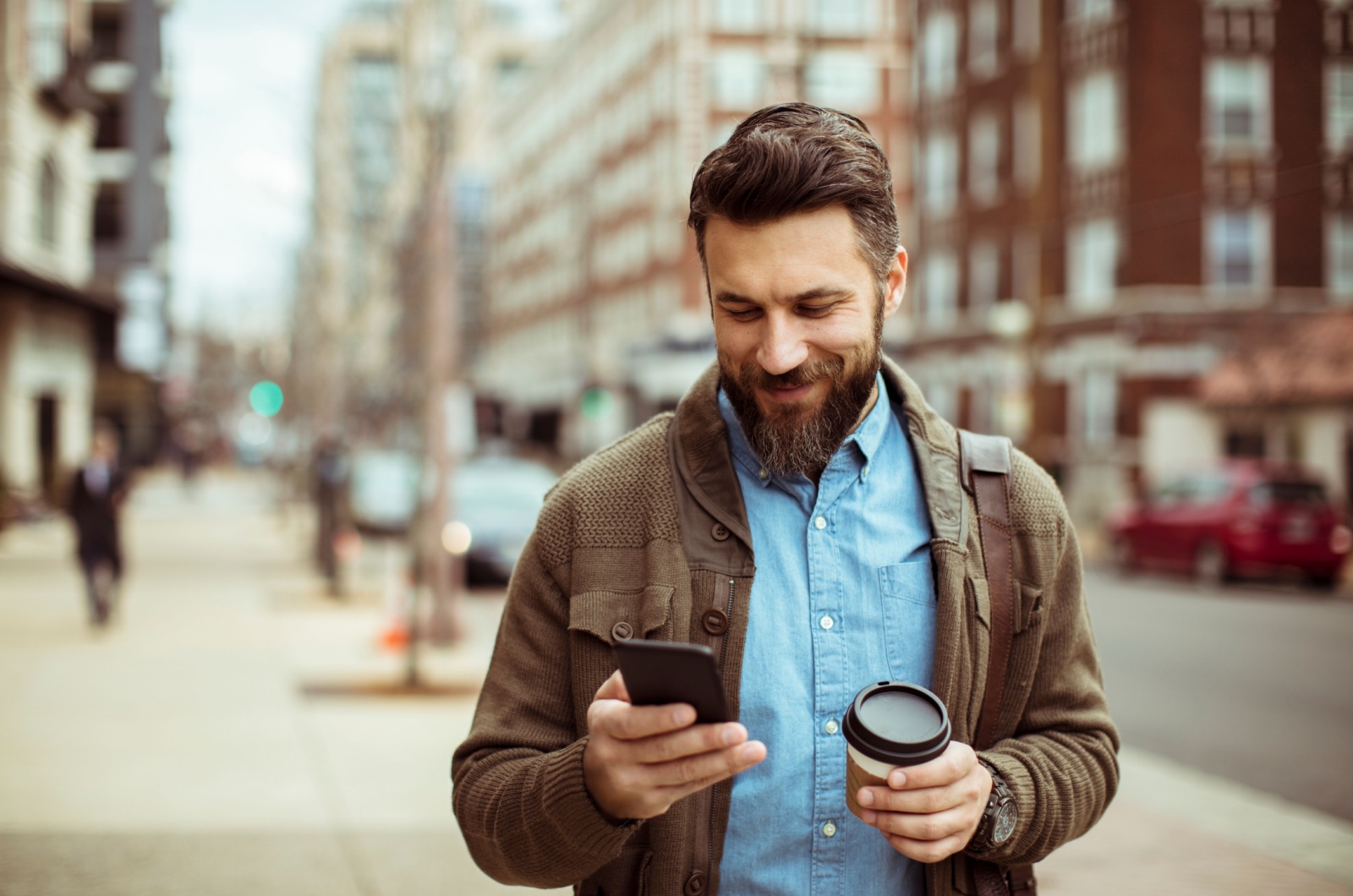 mann haelt kaffee und handy