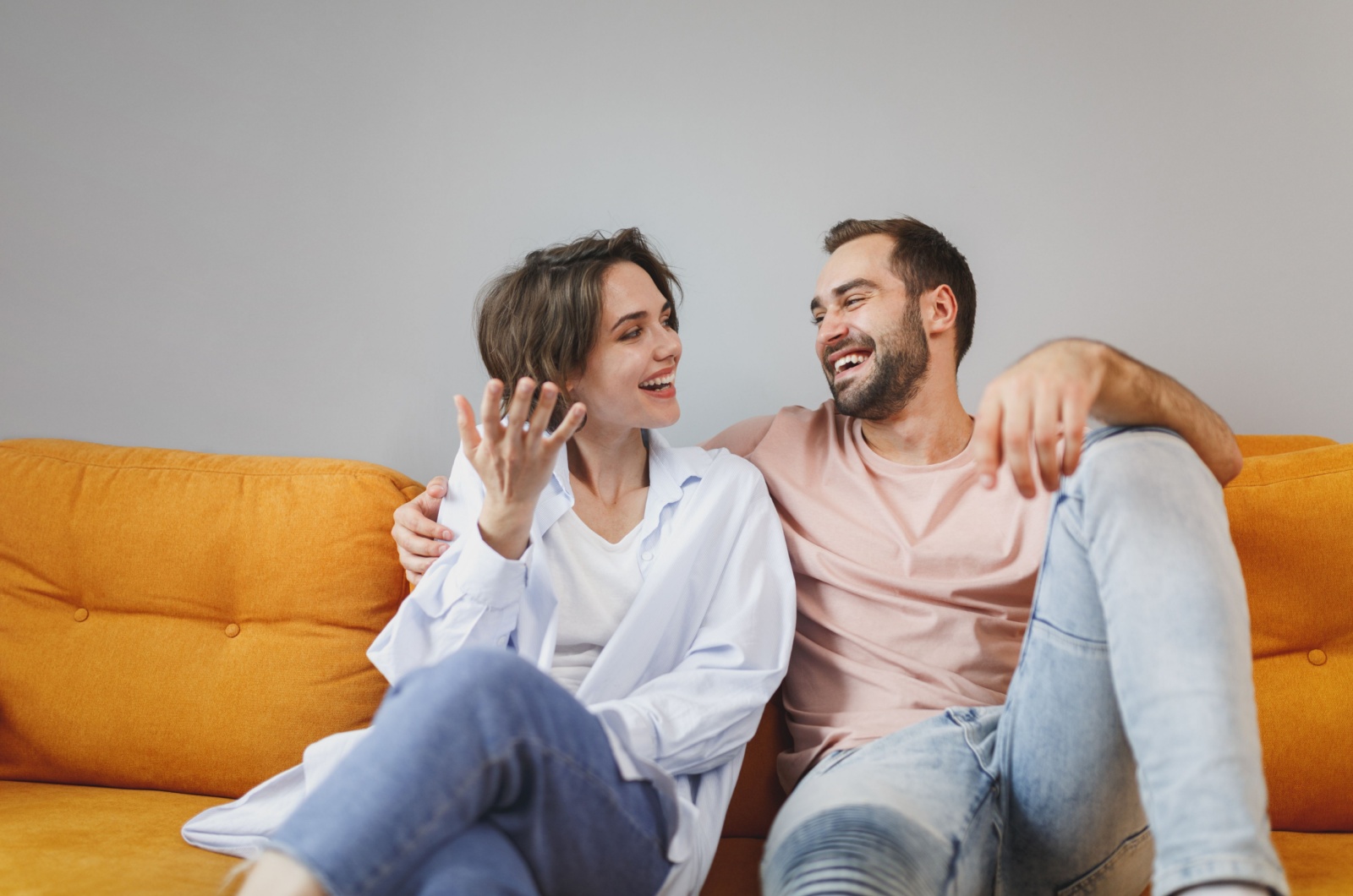 paar redet auf einer orangen couch