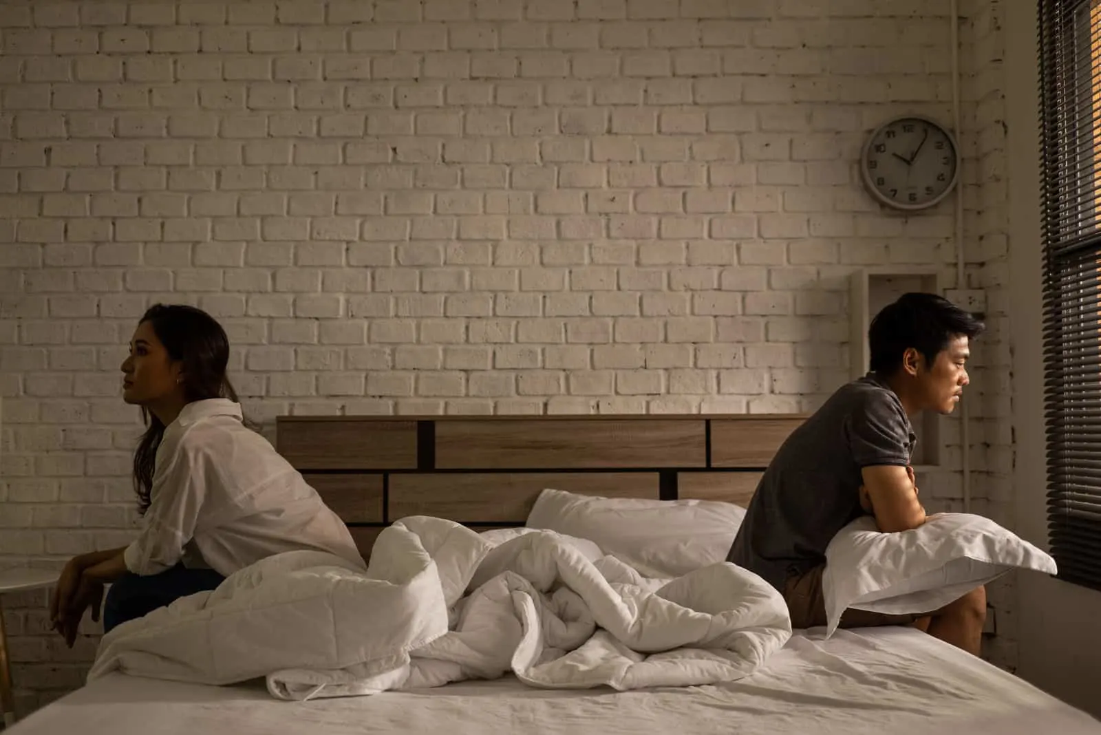 trauriges Paar sitzt auf dem Bett