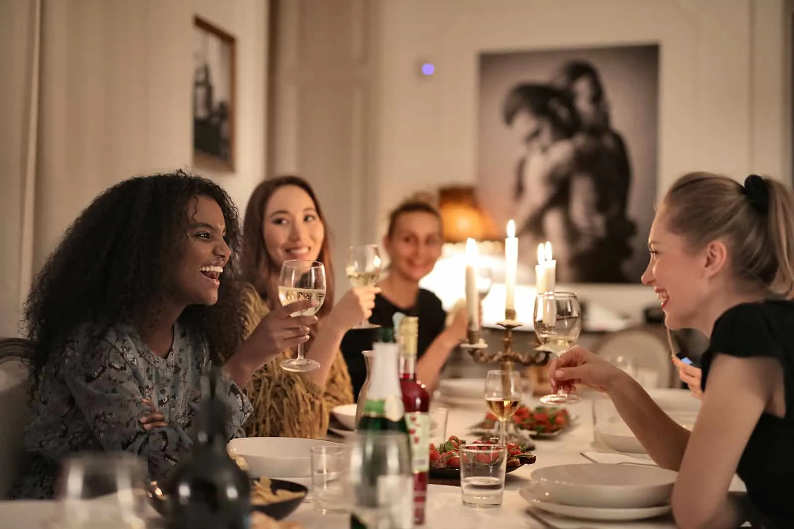 Eine Gruppe von Frauen, die sich beim Abendessen unterhalten und Wein trinken