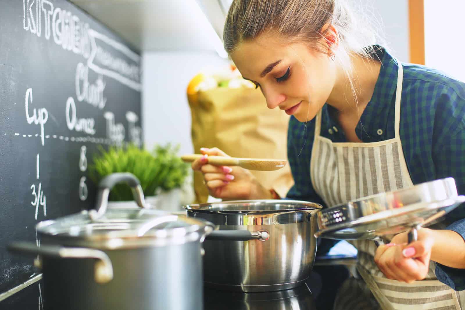 Junge Frau, die in ihrer Küche kocht