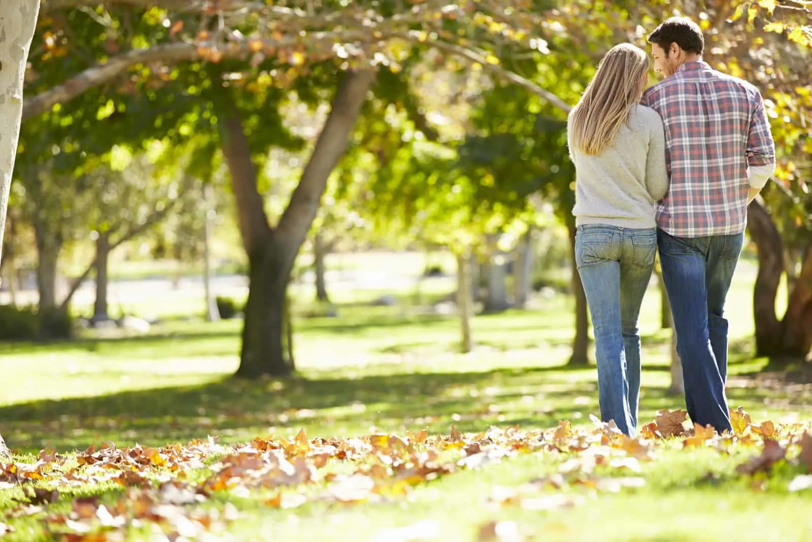 Romantisches Paar, das durch Herbst-Wald geht