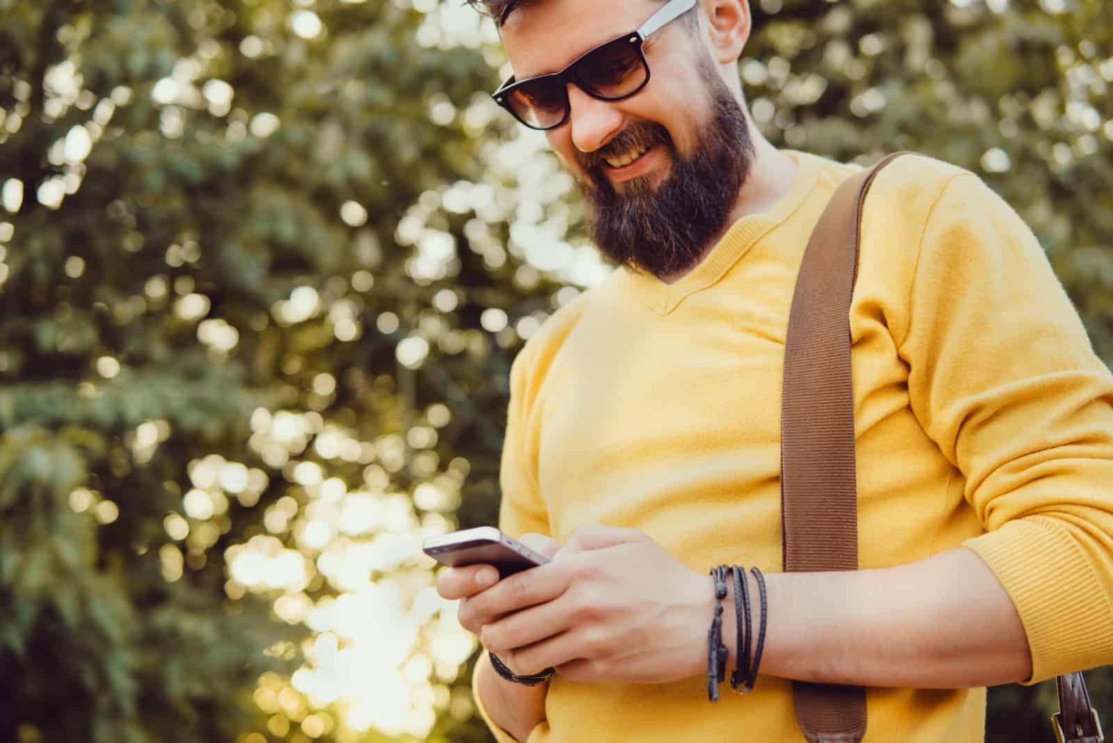 Schöner Mann Bart mit Smartphone in der Hand