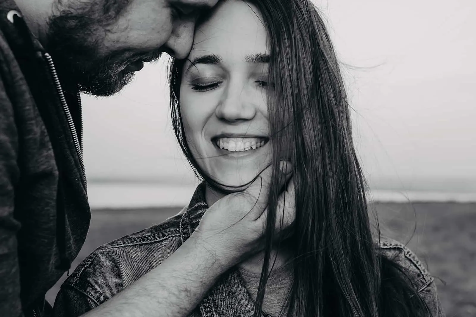 Ein lächelndes Mädchen schloss die Augen und ein Mann berührte ihr Gesicht