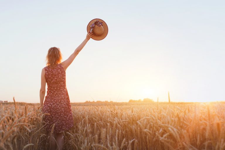Frau winkt Hand auf dem Feld