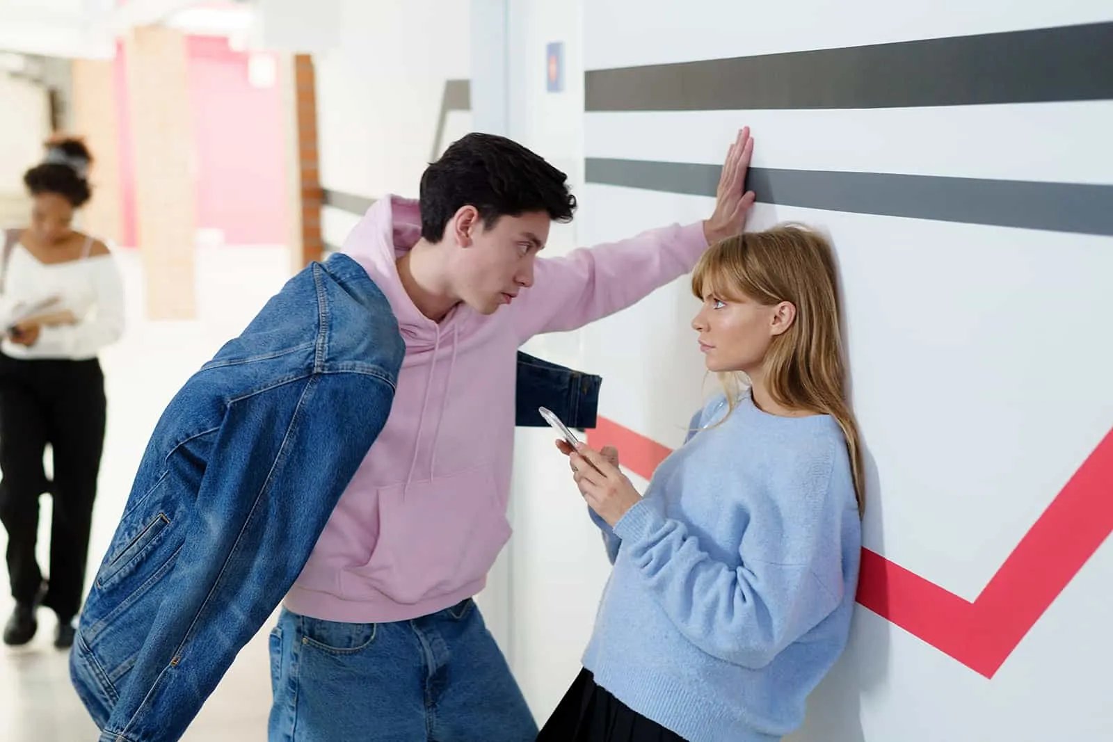 Ein Mann sah eine Frau an, die sich an die Wand lehnte und mit ihm flirtete