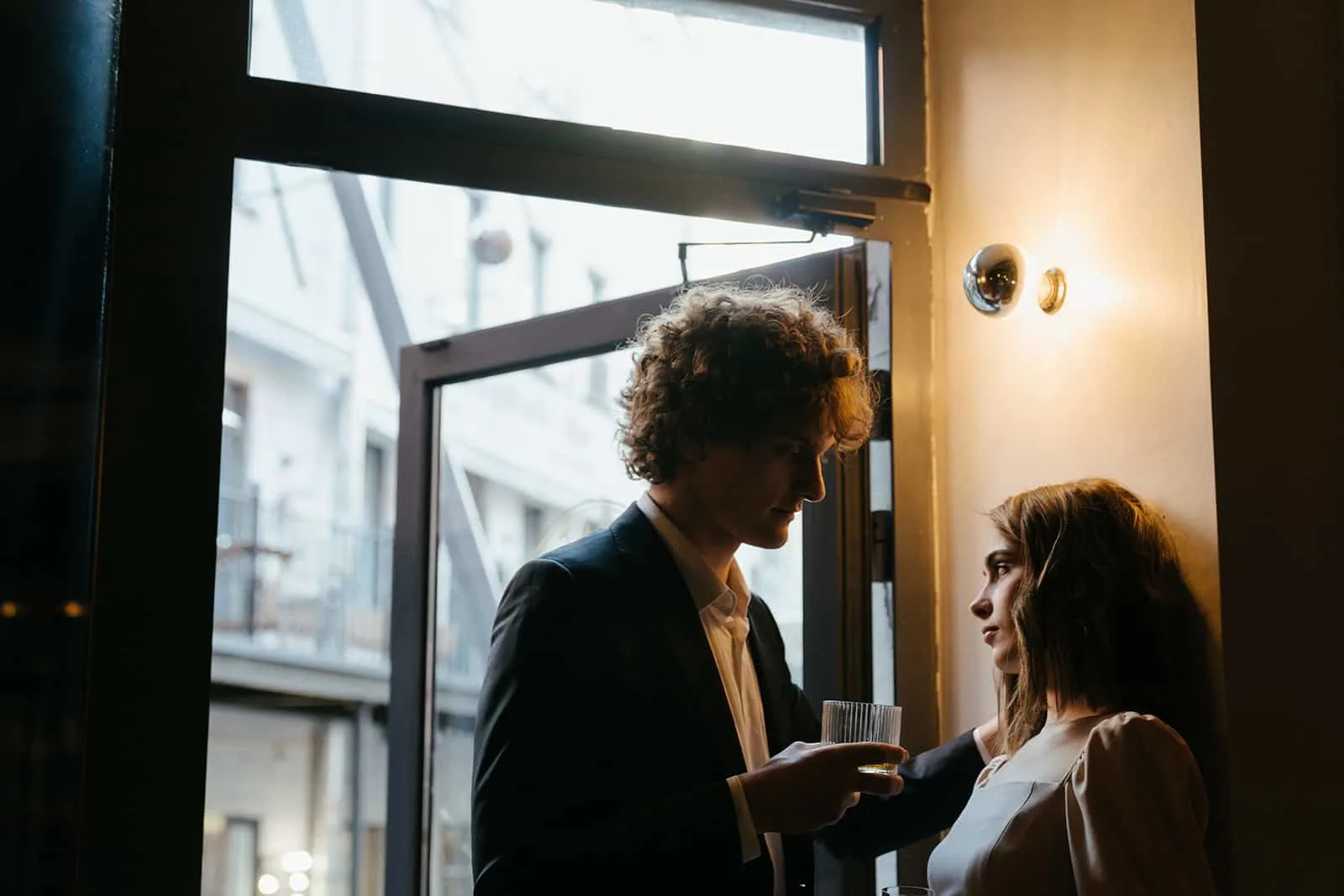 Ein Mann und eine Frau flirten, während sie in der Nähe der Tür standen