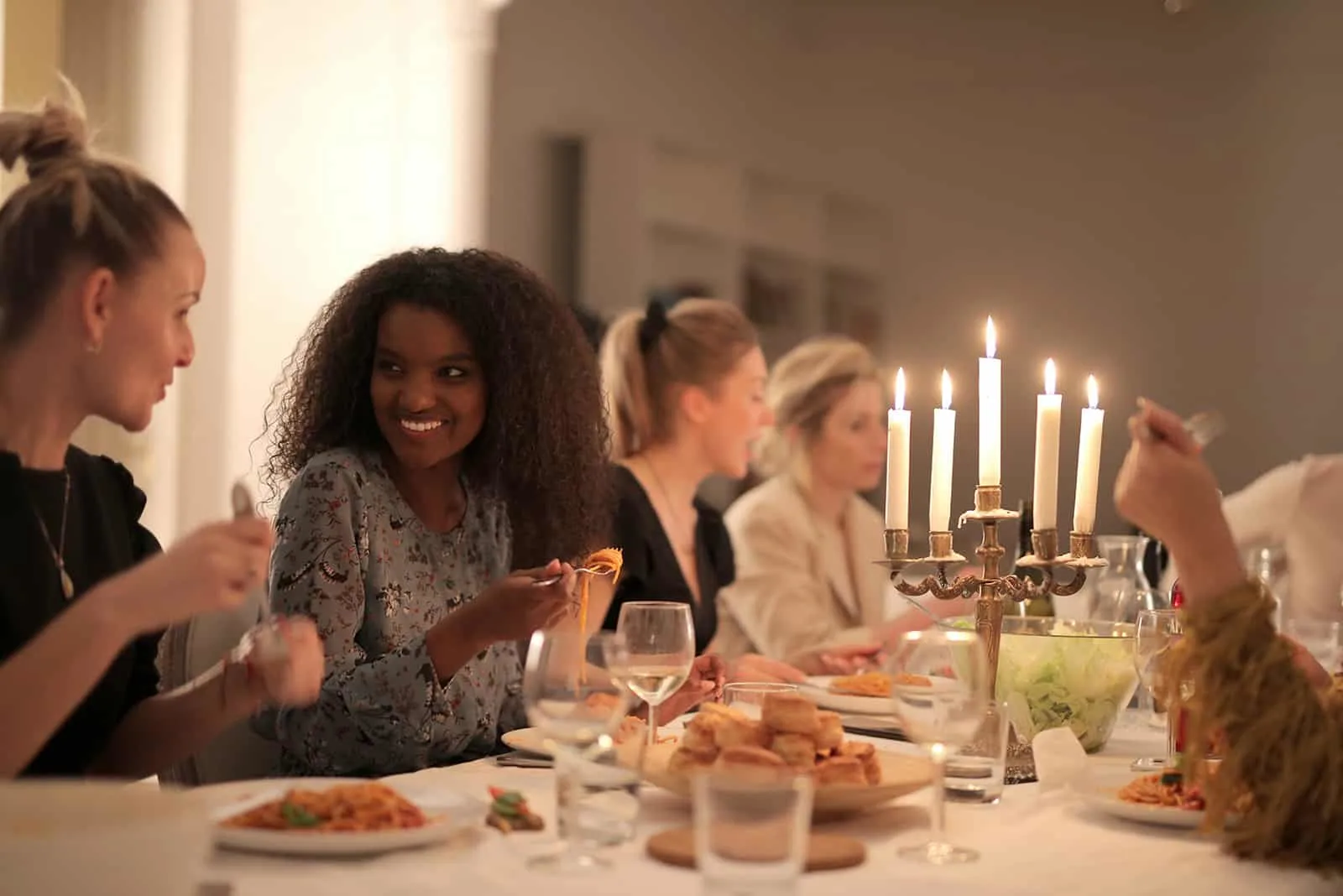 eine Gruppe von Frauen, die zu Abend essen, reden und lächeln