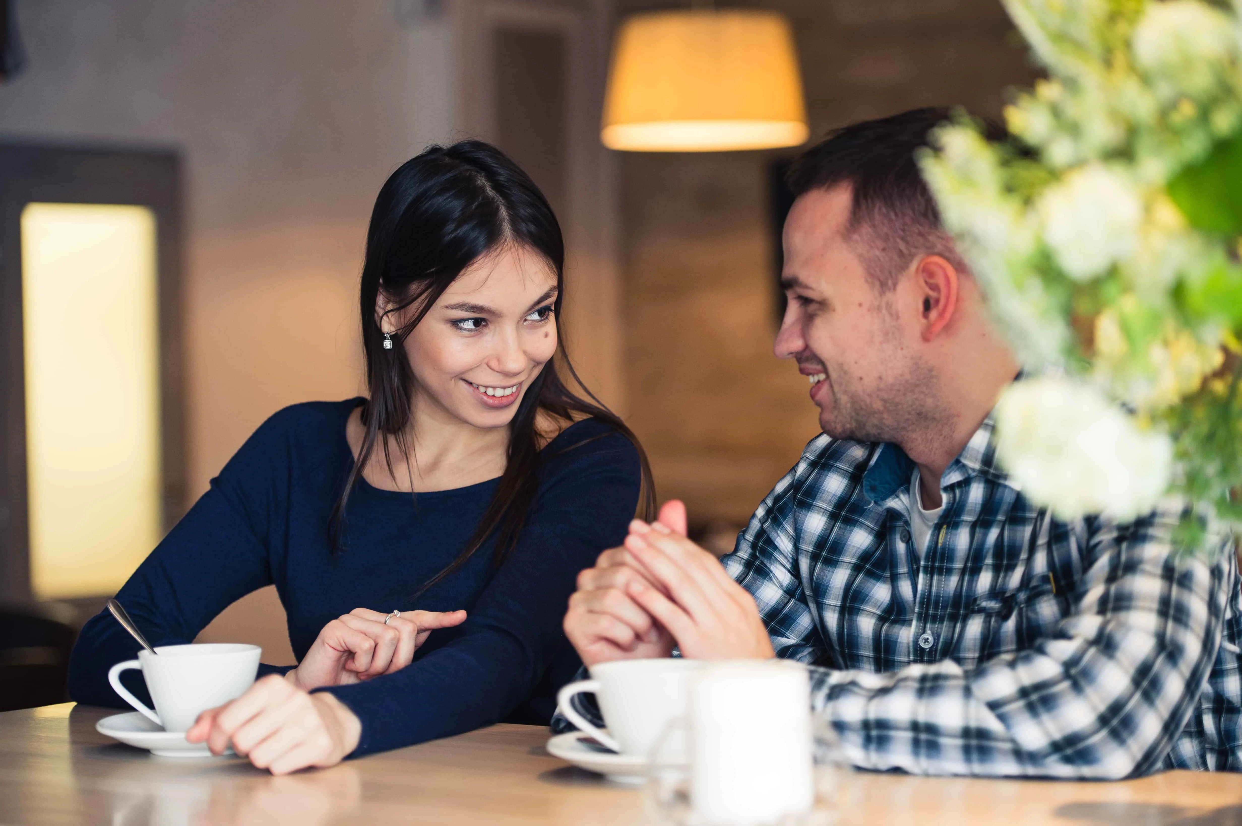 Eine lächelnde Frau, die mit einem Mann im Café über ein Date spricht