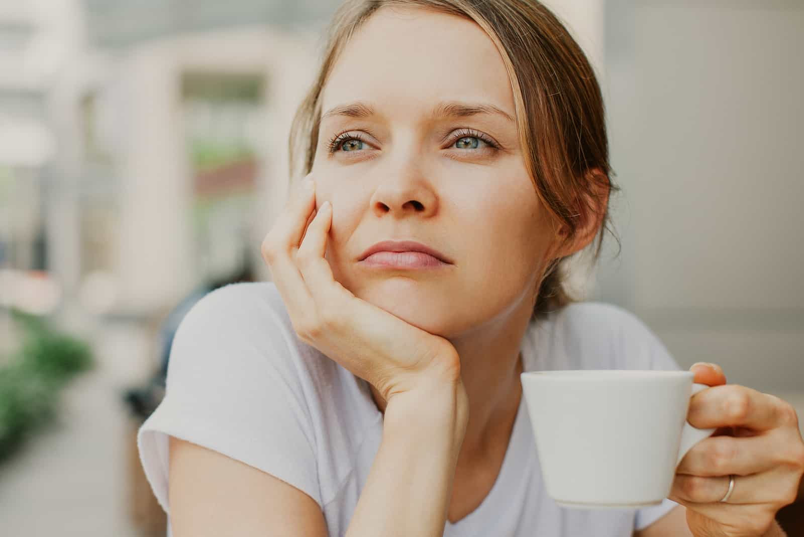 nachdenkliche junge schöne Frau, die Kaffee trinkt