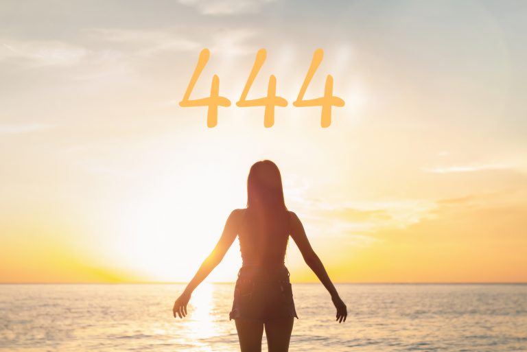 Frau, die vor dem Meer während des Sonnenuntergangs steht