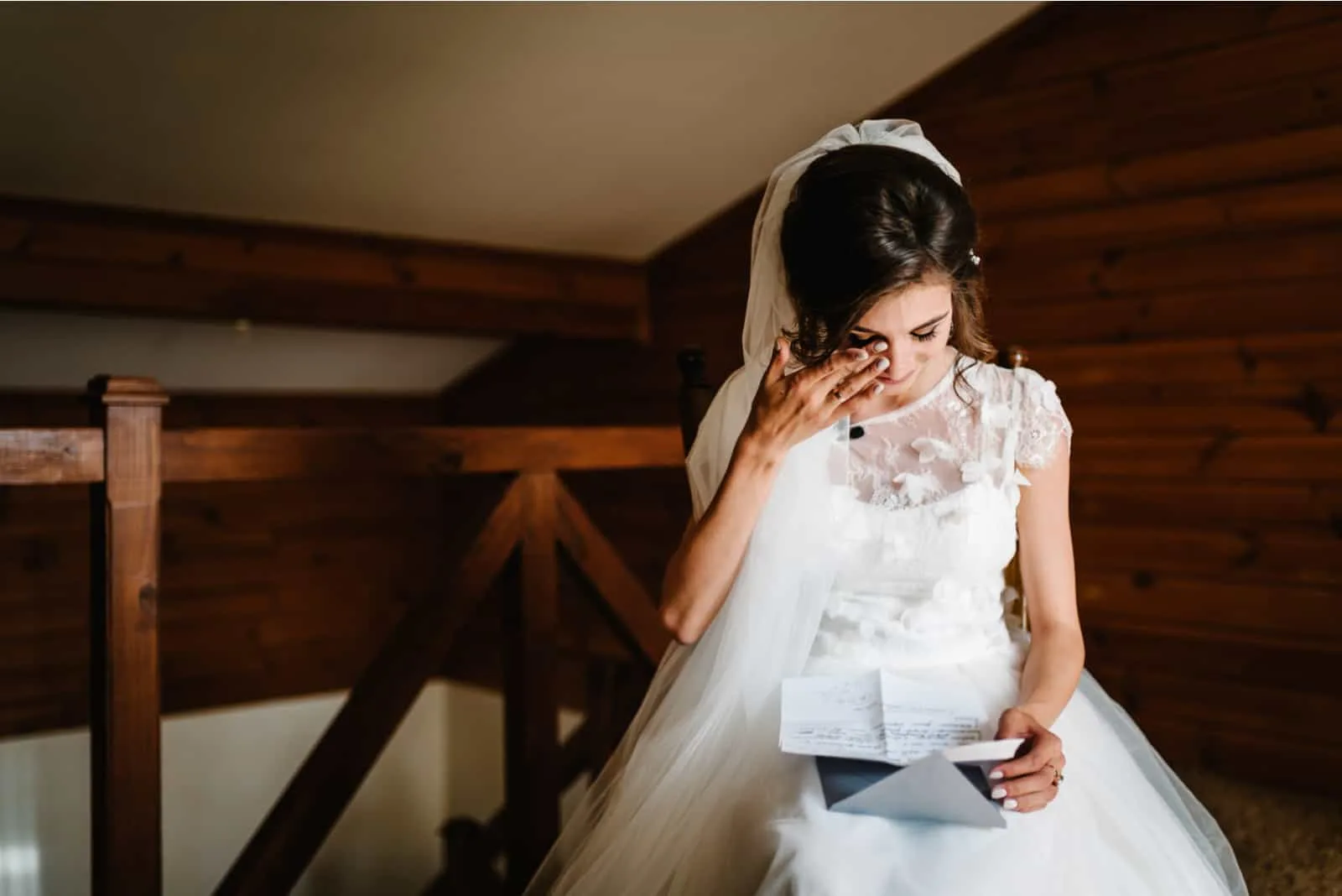 Die Frau im Hochzeitskleid liest den Brief und weint