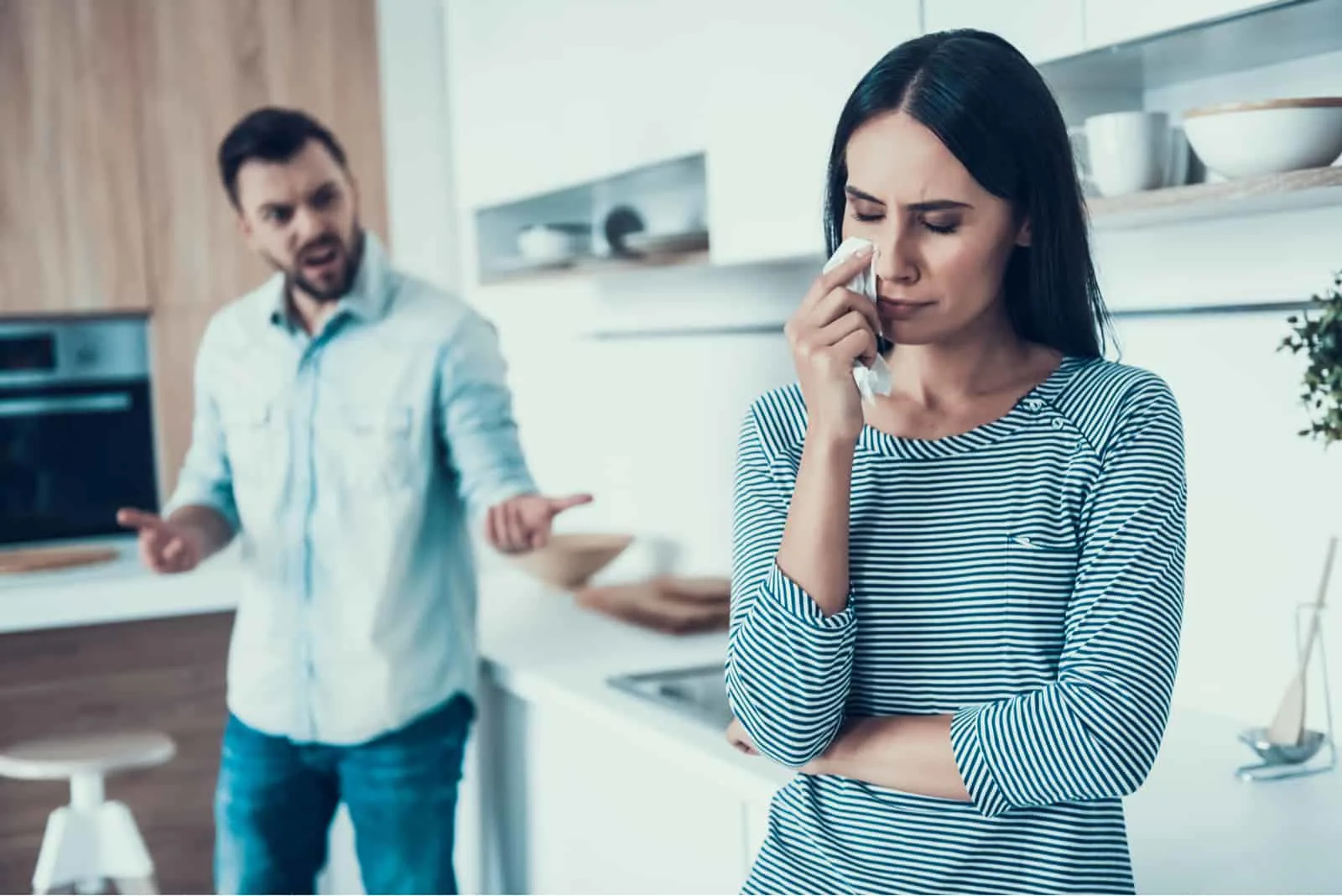 Ein Mann in der Küche schreit seine traurige Frau an