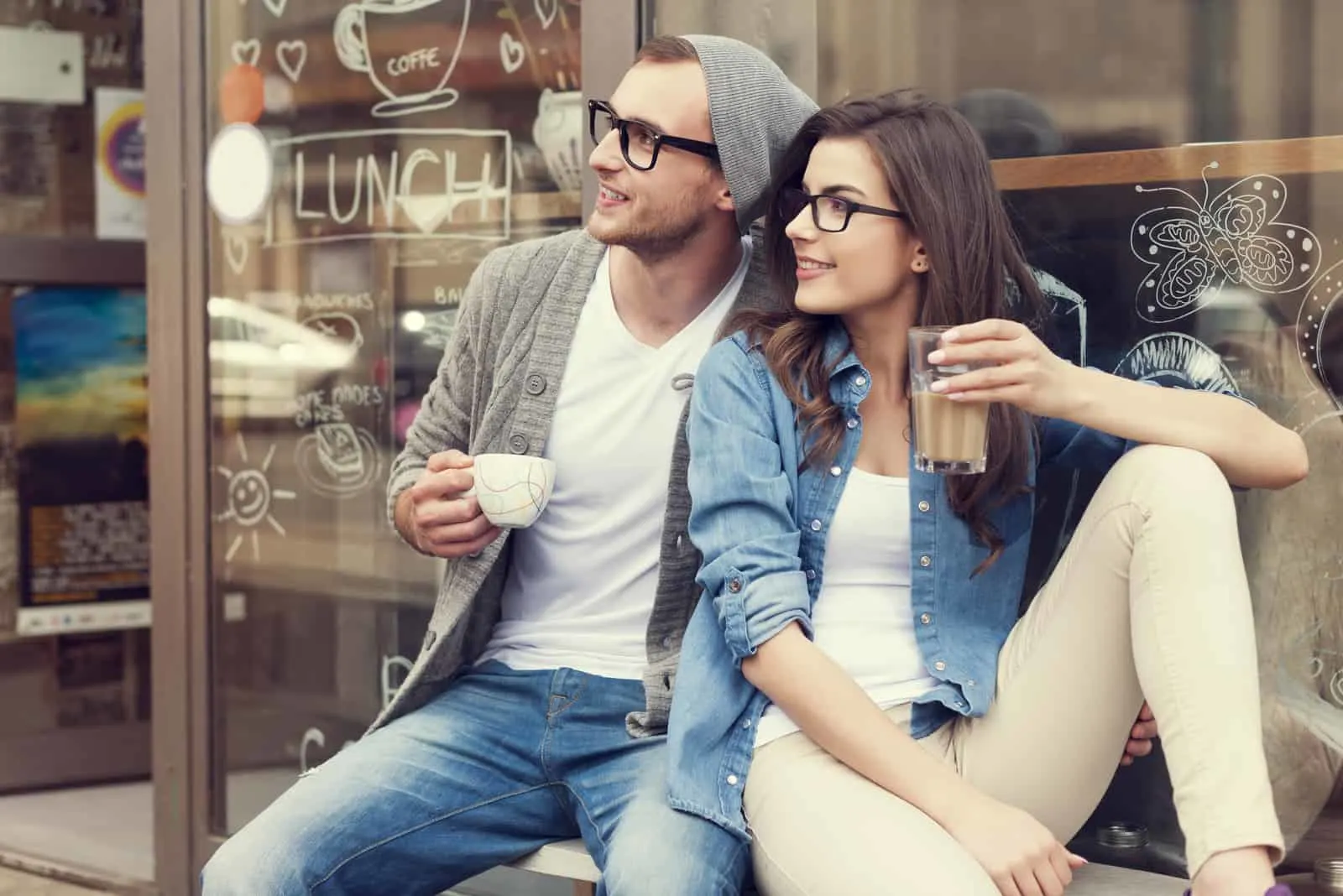 Ein Mann und eine Frau sitzen beim Kaffeetrinken und schauen in die Ferne