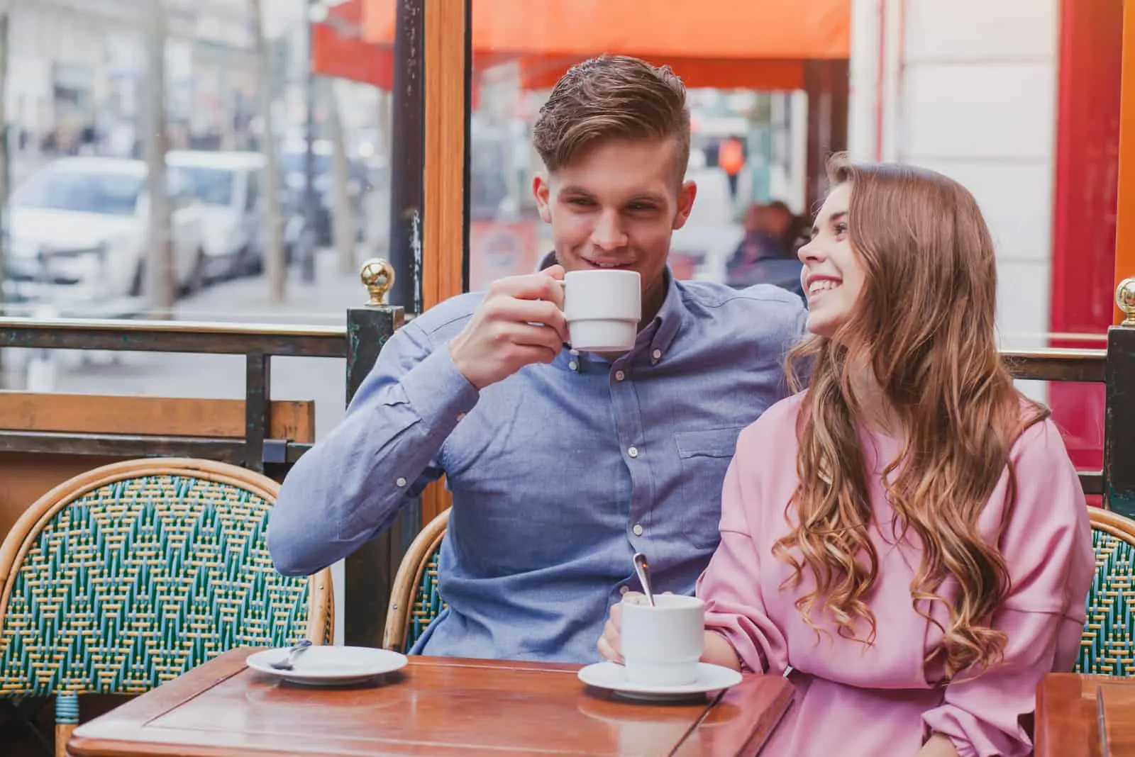 Ein Mann und eine Frau sitzen, trinken Kaffee und lachen