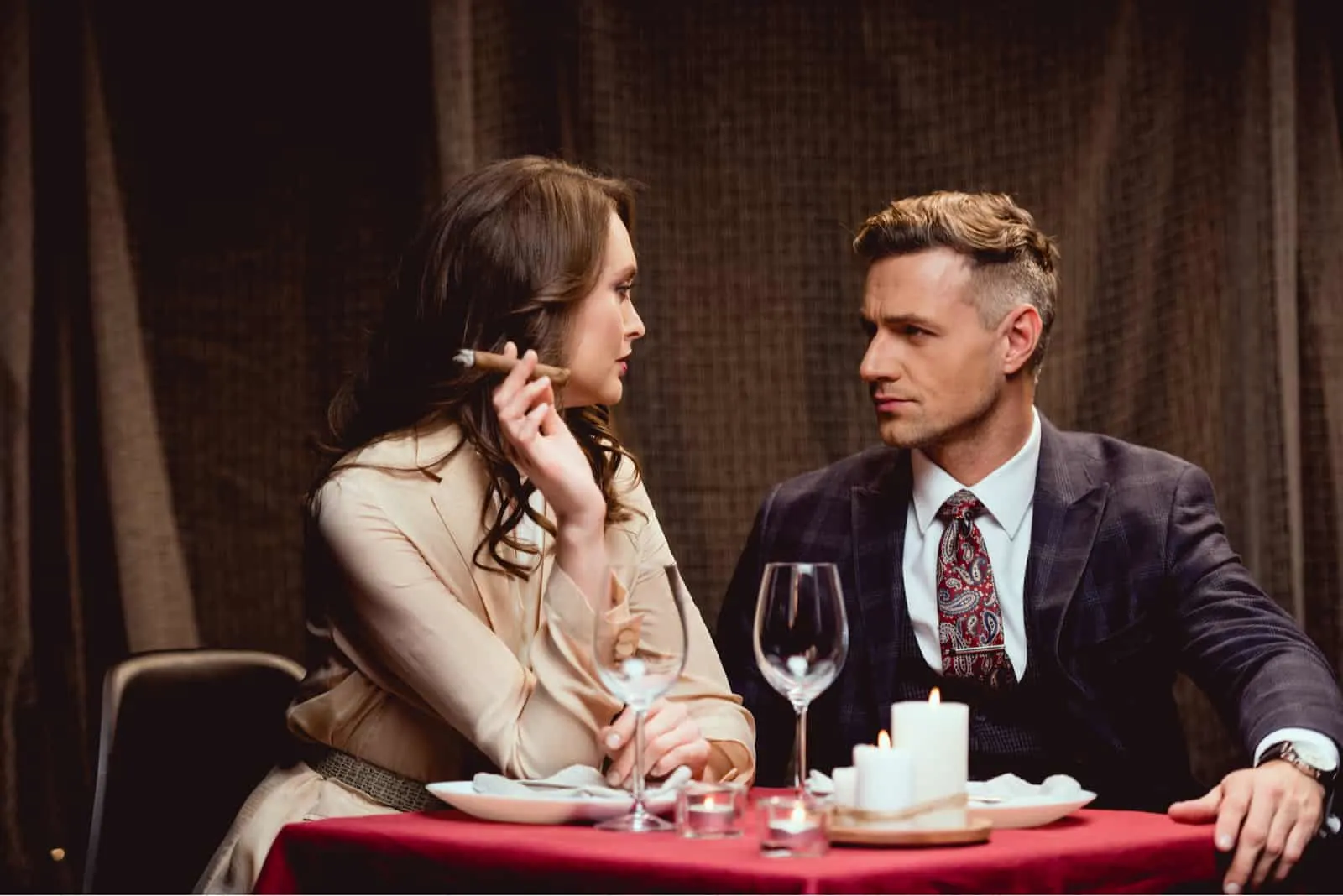 Eine Frau und ein Mann sitzen an einem Tisch, während sie eine Zigarre rauchen