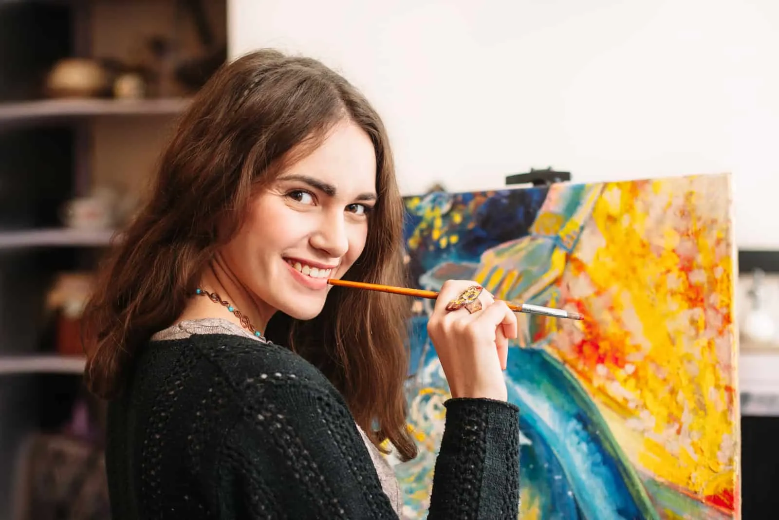 Eine lächelnde Frau malt ein Bild