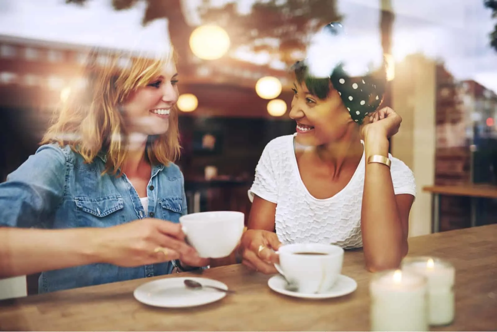 In einem Café hinter der Bar sitzen zwei schöne Frauen, die Kaffee trinken und reden