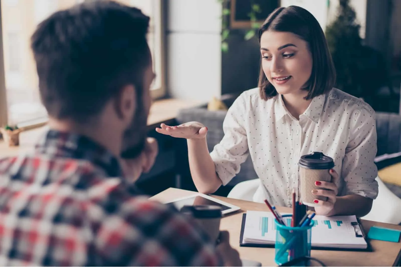 Ein Mann und eine Frau sitzen in einem Café und streiten sich