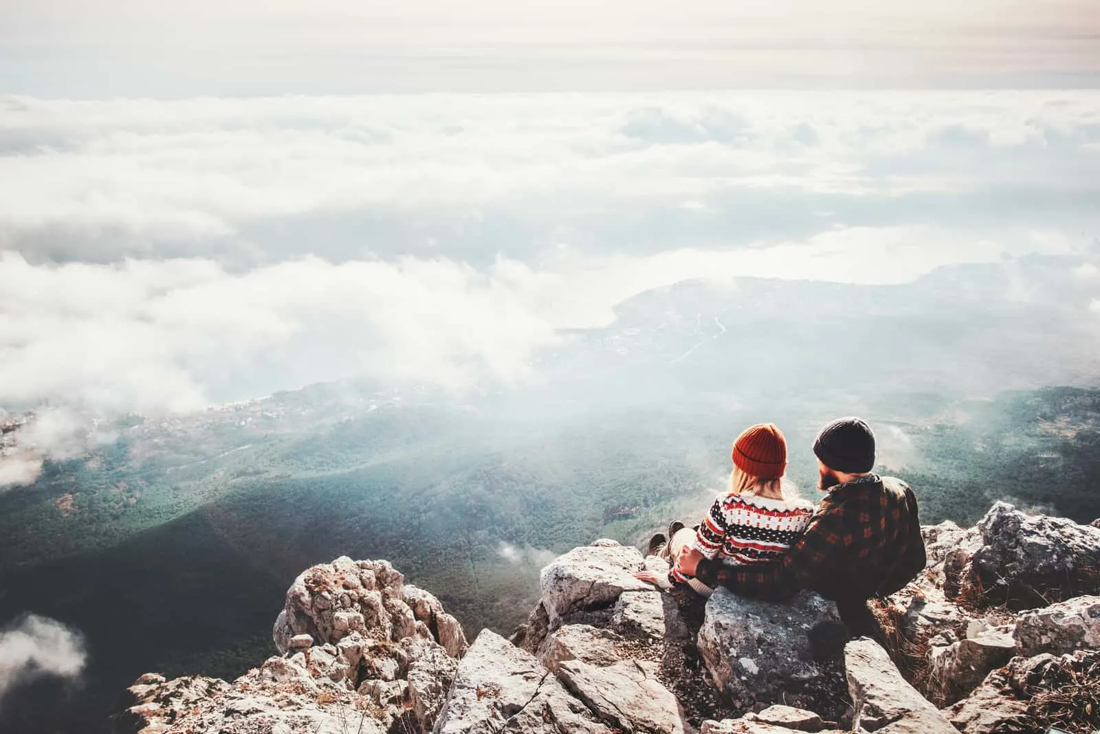 Mann und Frau sitzen auf Klippe entspannend