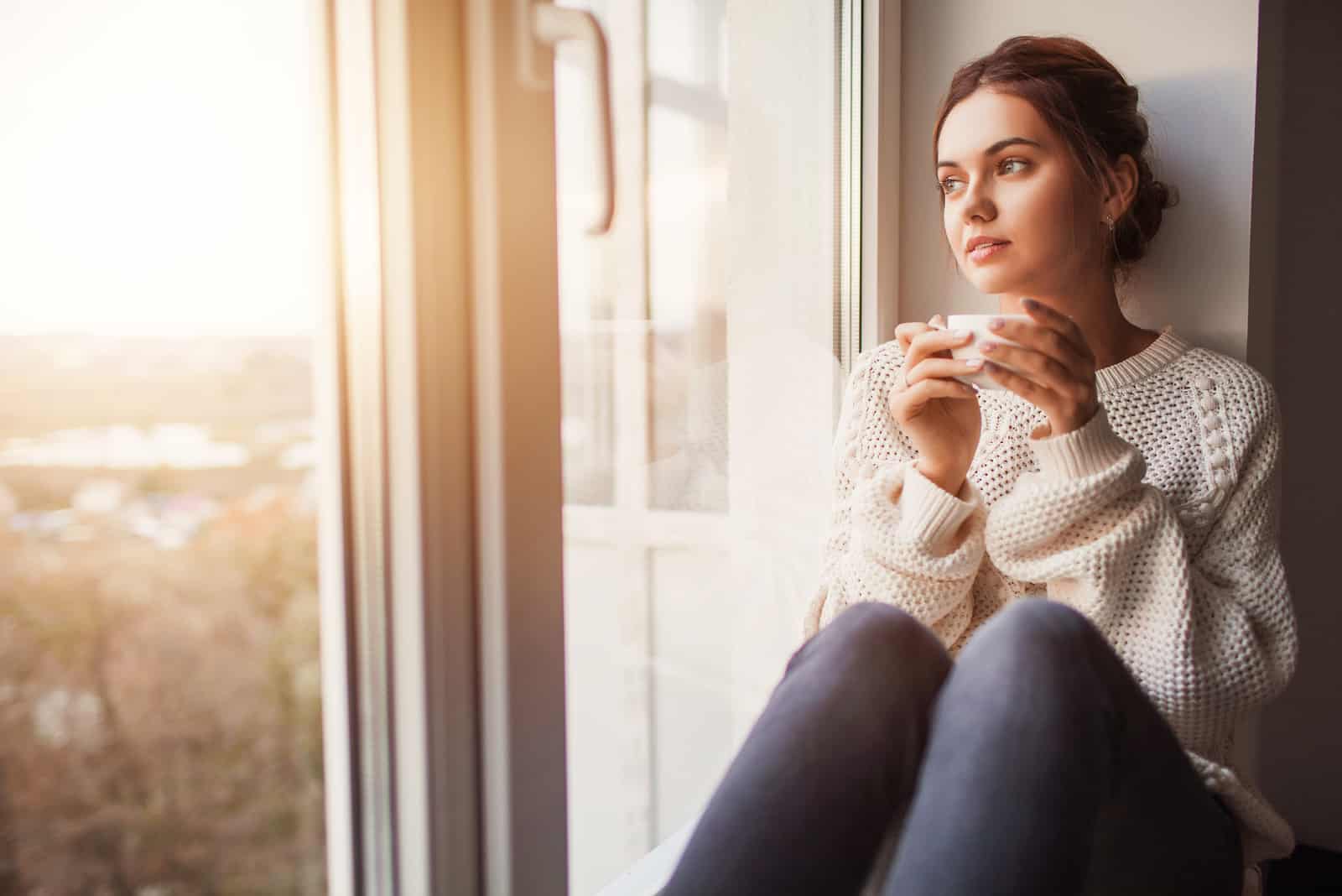 Schöne junge Frau, die Kaffee trinkt