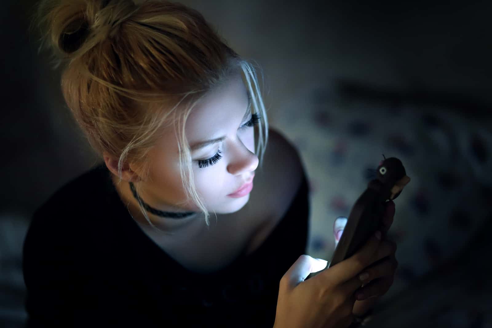 Frau, die Smartphone nachts auf Bett verwendet