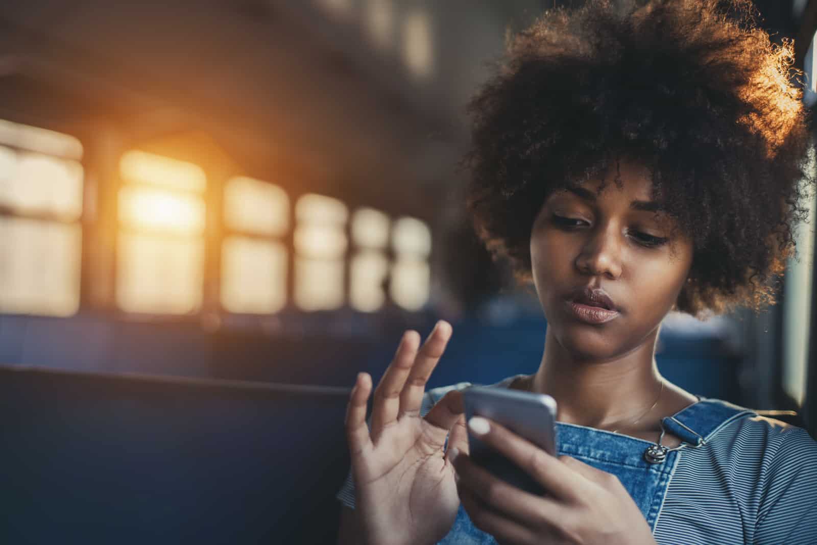 Mädchen mit Smartphone, während allein in der S-Bahn sitzen