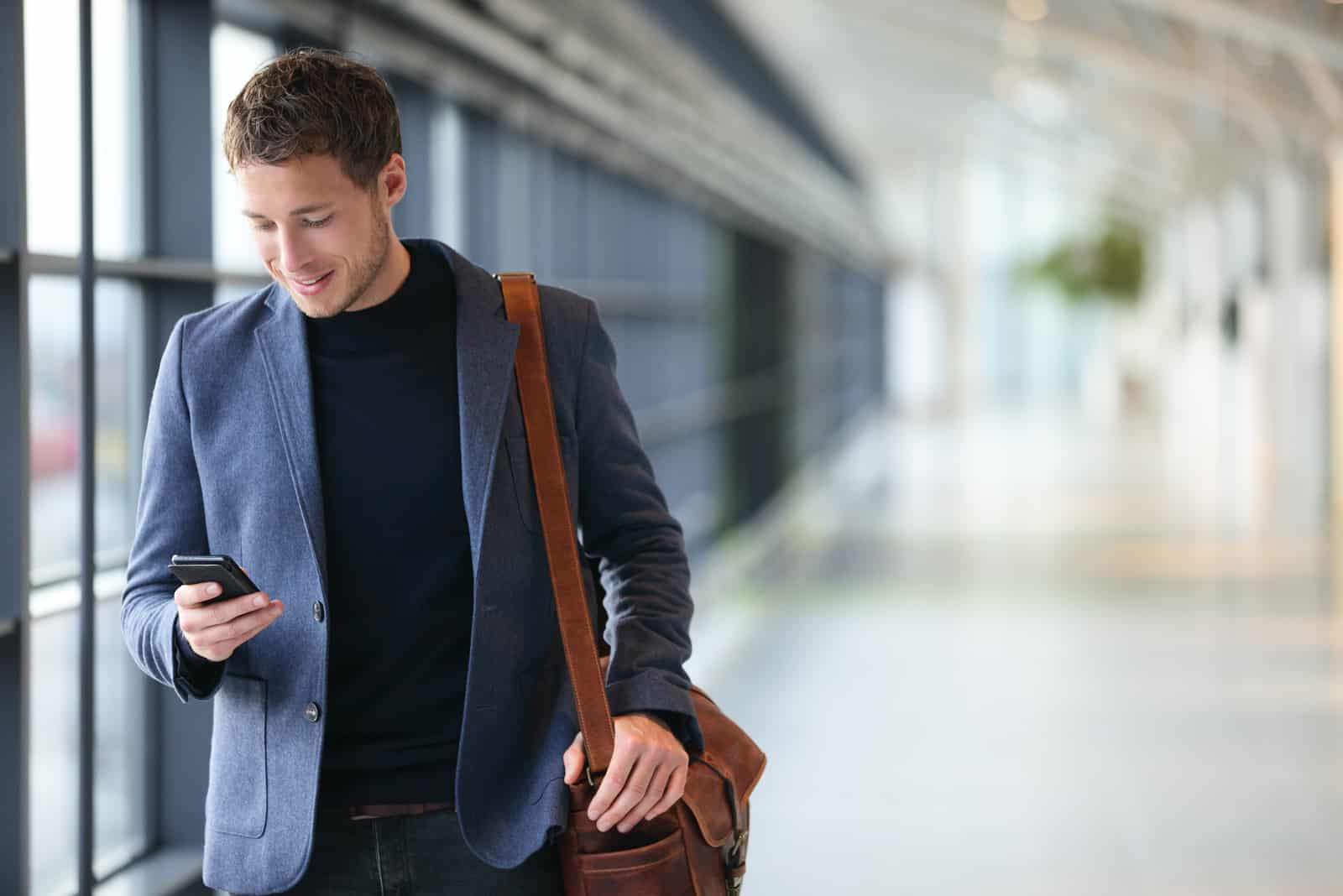 Mann hält Telefon lächelnd
