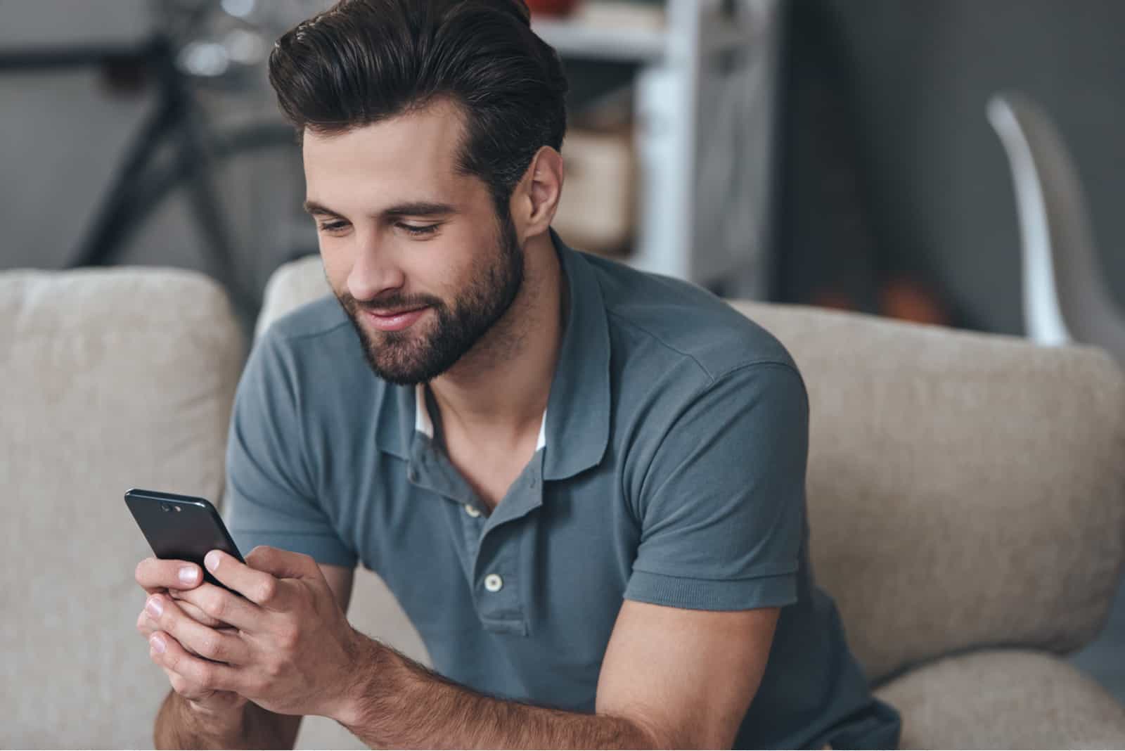 Mann hält Telefon und lächelt