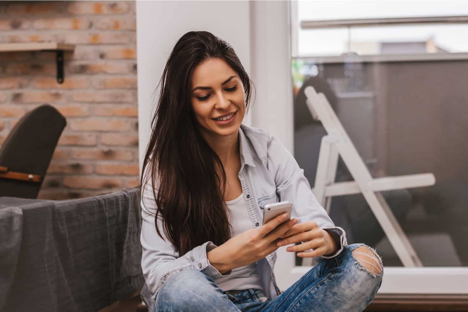 Mädchen mit ihrem Smartphone zu Hause