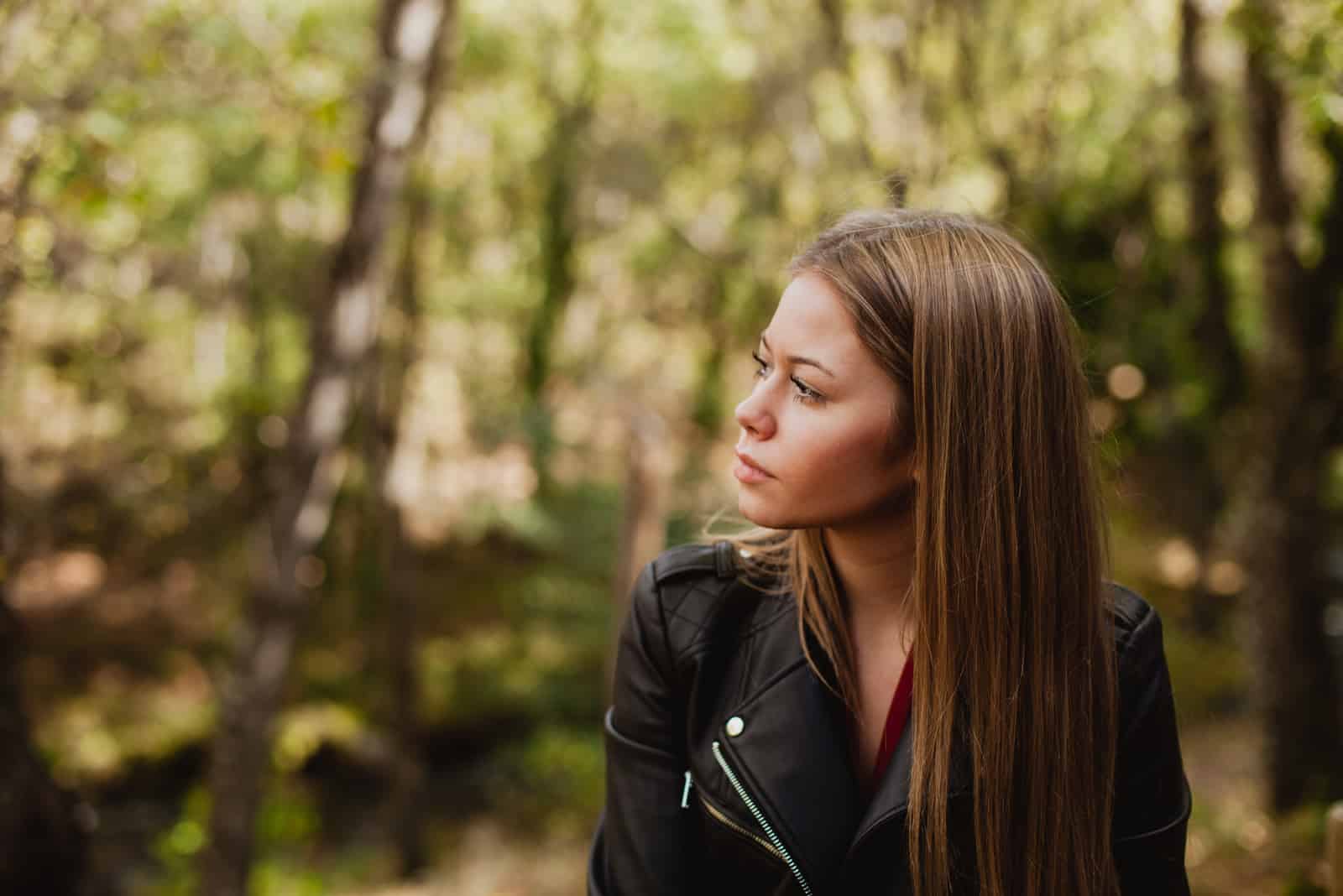 Nachdenkliche Frau in einem schönen Wald im Herbst