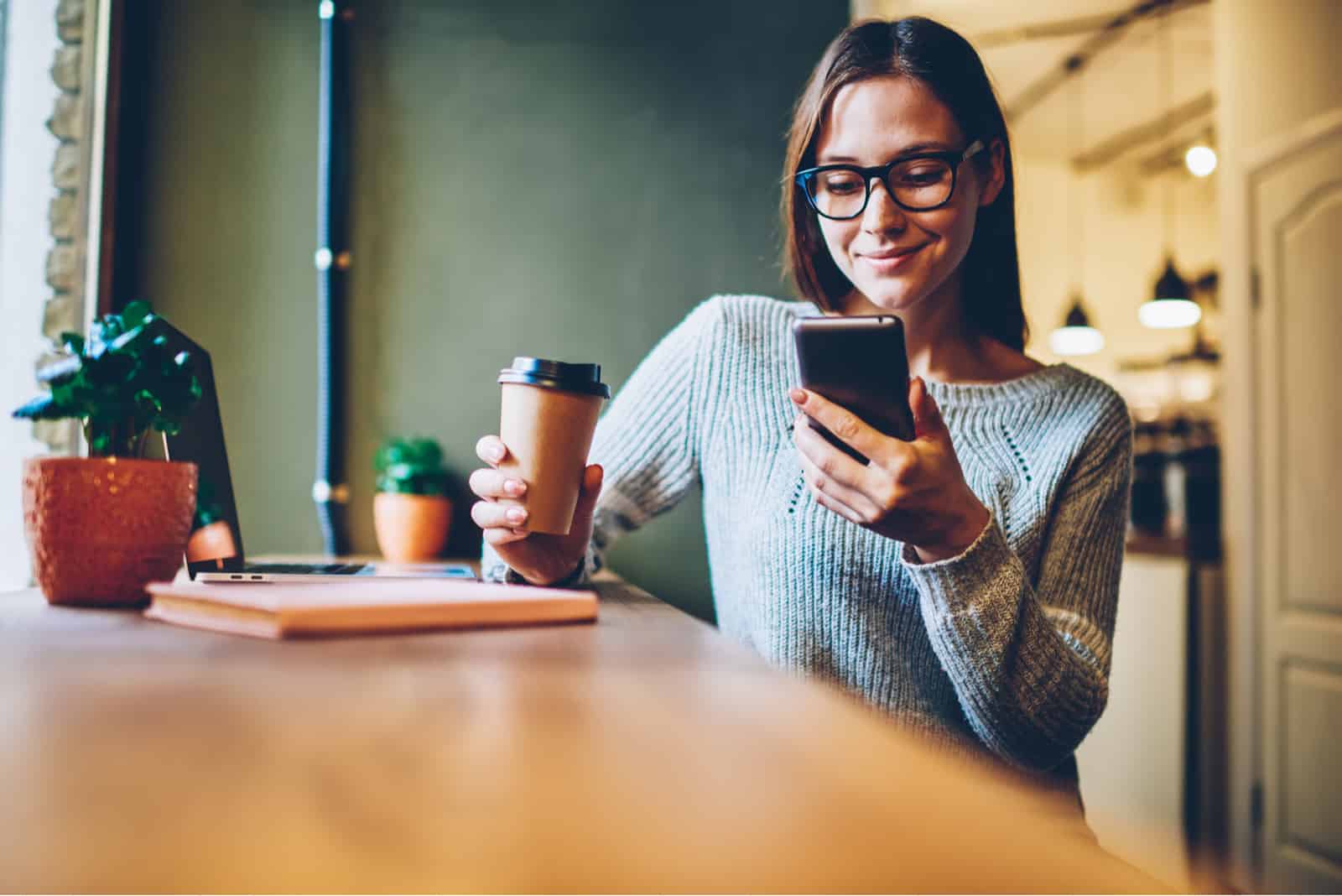 Frau hält Telefon und lächelt