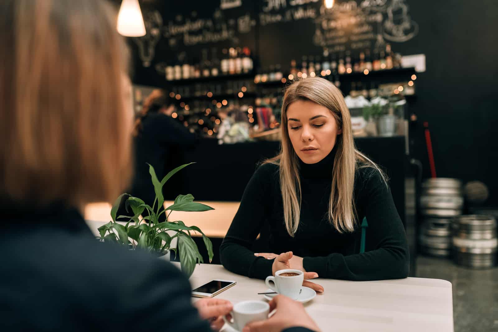 Zwei Freundinnen in einem Café, die ein ernstes Gespräch führen