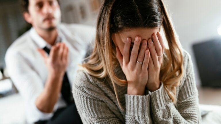 frau weint neben wuetendem partner