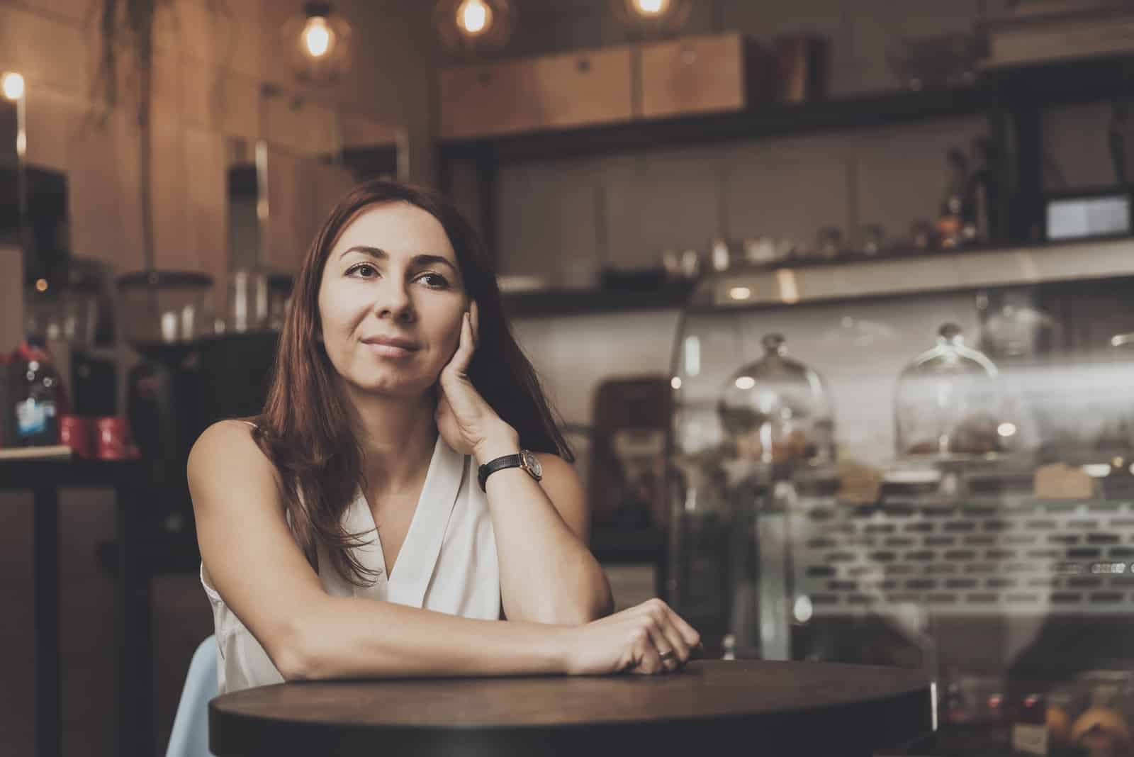 Mädchen sitzt in einem Café und wartet auf einen jungen Mann